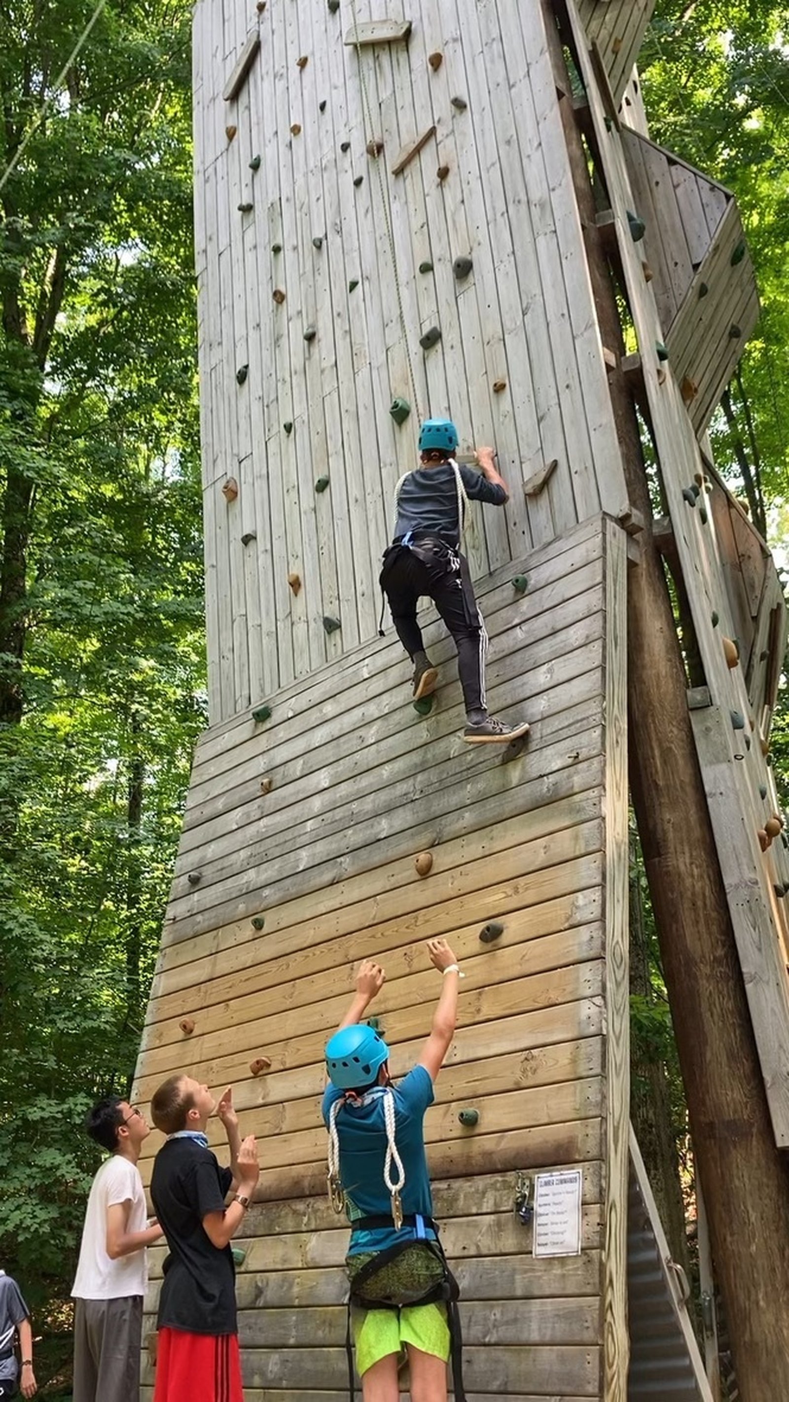 Campers climb a rock wall that remains a fixture at Camp Sancta Maria, a northern Michigan summer camp that offers recreation and spiritual opportunities for boys and girls.