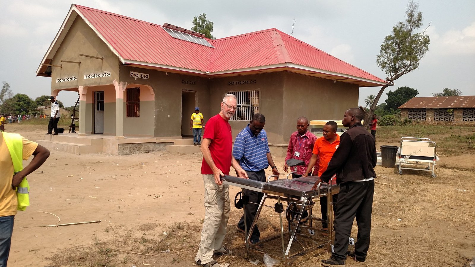 Deacon Joe Hulway (red shirt), Fr. Ikanga and local doctors examine a delivery table purchased for the Yassa women's maternity clinic, which finished construction and was dedicated in July 2019.