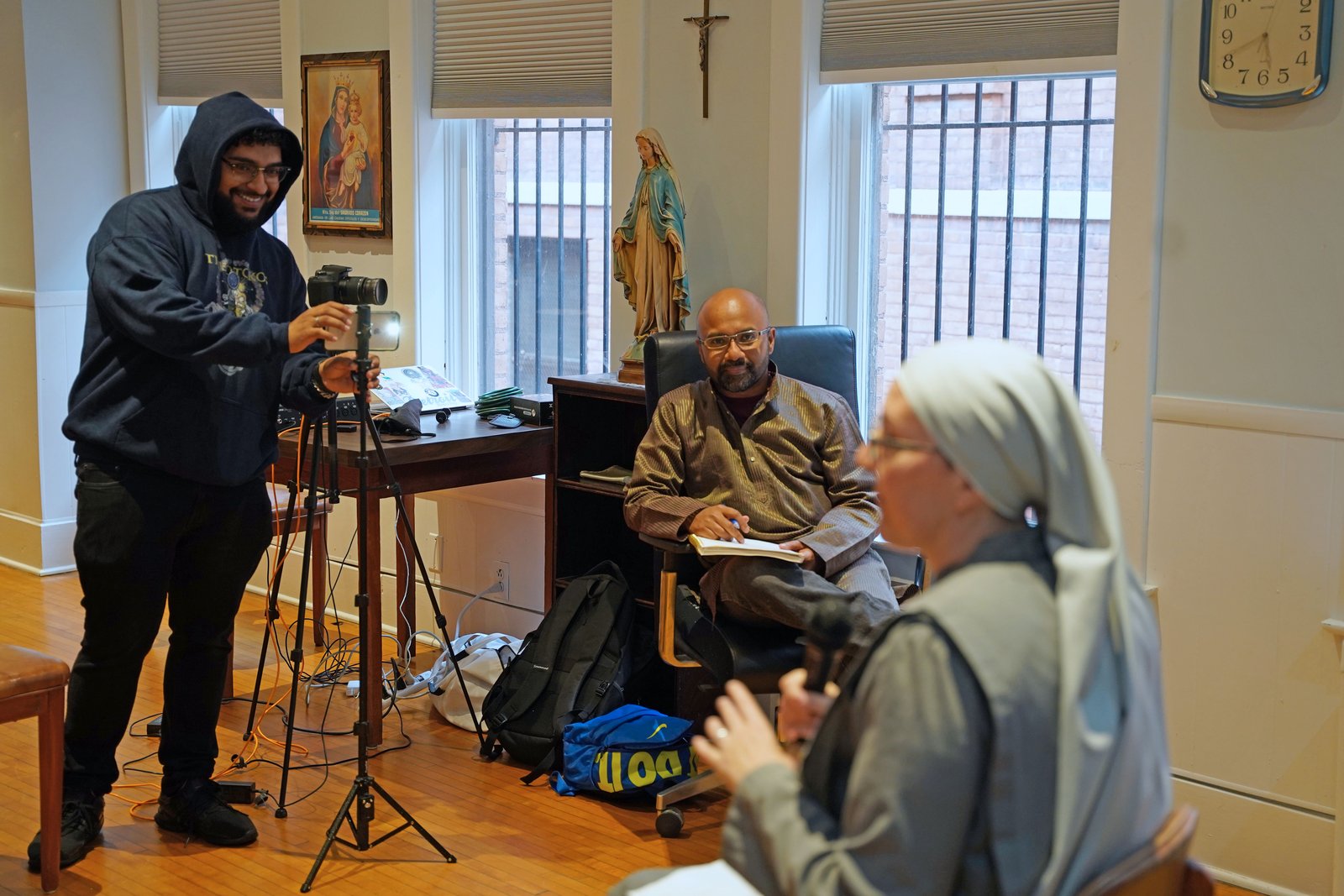Ricardo Hernandez, left, and Jerin Philip record Sr. Kateri Burbee, SOLT, principal of Holy Redeemer School, as she gives a talk about St. John Paul II's Theology of the Body via Facebook Live on Sept. 24.