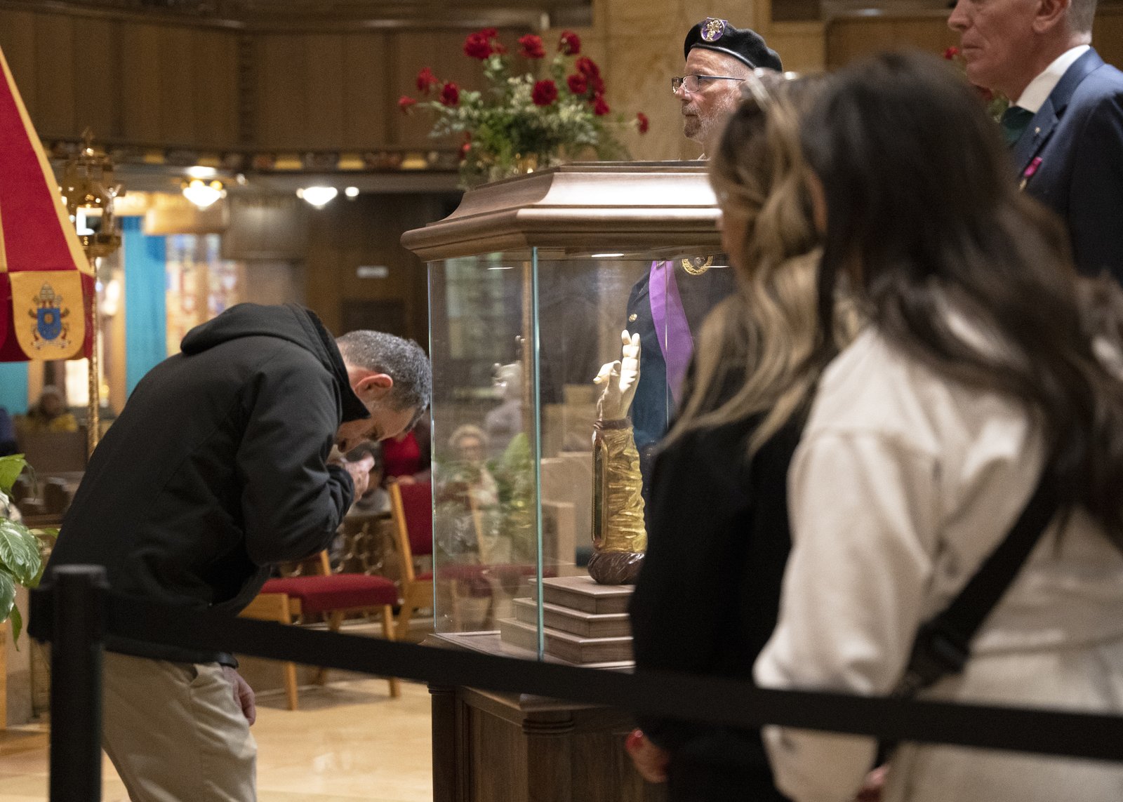 Linda Kanna's husband venerates the relic as her daughters wait in line.