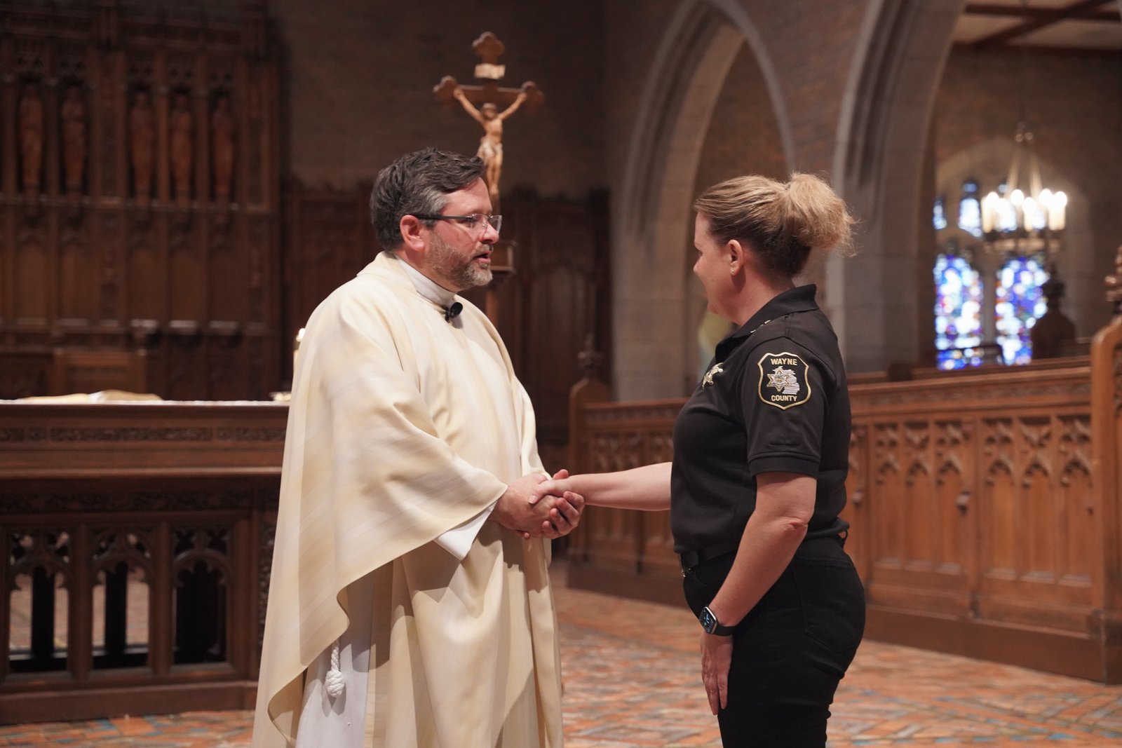 Fr. Mark Livingston greets Dawn T. Johnson, community liaison for the Wayne County Sheriff's Department, after the Mass for First Responders at Sacred Heart Major Seminary.