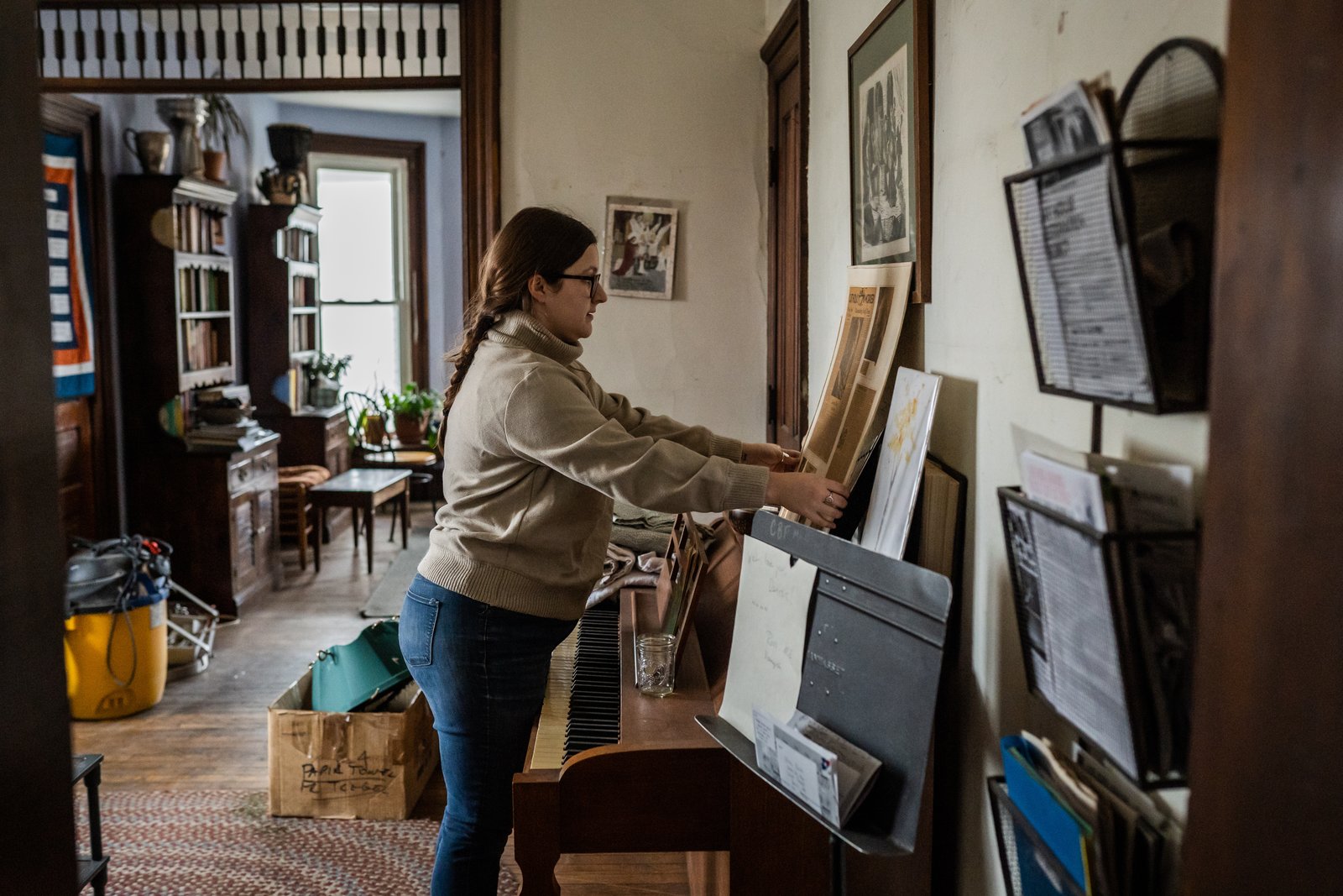 Jordan Kennedy coloca un artículo del periódico sobre la comunidad de Trabajadores Católicos en la pared de Day House en Trumbull Avenue. La comunidad mundial de Trabajadores Católicos fue cofundada en la década de 1930 por Dorothy Day.