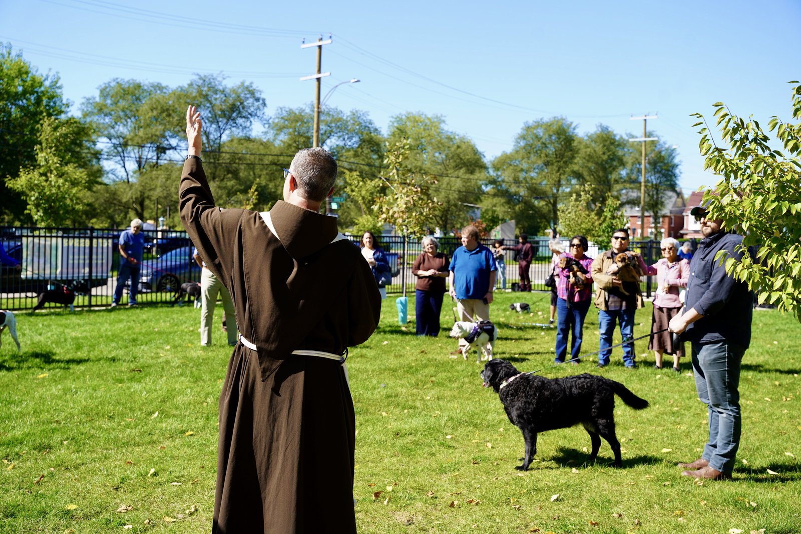 Fr. Mark Soehner, OFM, blesses dogs, cats and other animals along with their owners during a gathering after Mass on Oct. 4 at Holy Paws Dog Park in Detroit.