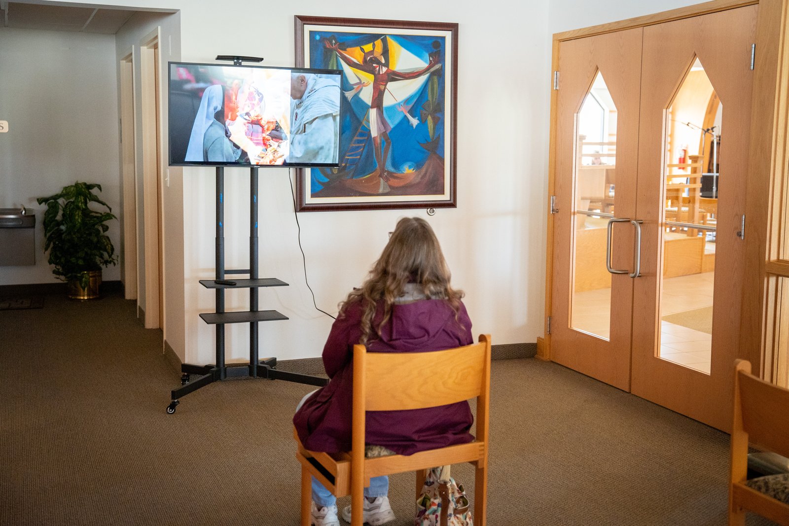 Una mujer mira el vídeo que acompaña a la exposición de milagros eucarísticos en la parroquia de San Roque, en Flat Rock. A lo largo de la historia de la Iglesia se han producido milagros eucarísticos, poderosos recordatorios de la presencia sobrenatural de Dios en todas y cada una de las misas.