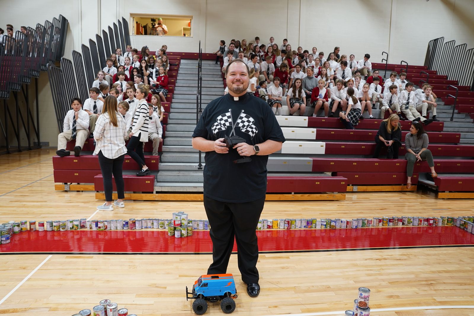 Fr. Andrew Smith of St. Paul on the Lake Parish in Grosse Pointe Farms was the winning driver in the grand prix the school hosted to celebrate how much food it collected. In total, St. Paul on the Lake students collected 5,313 cans and boxes of food. (Daniel Meloy | Detroit Catholic)