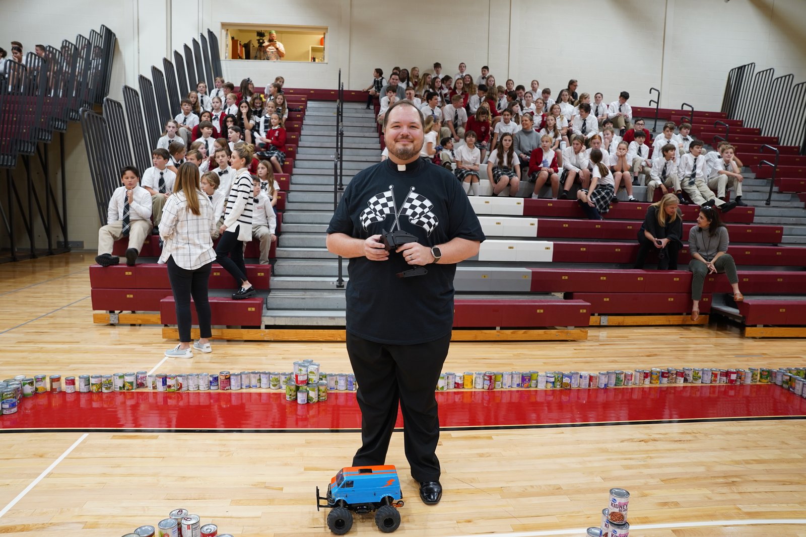 Fr. Andrew Smith of St. Paul on the Lake Parish in Grosse Pointe Farms was the winning driver in the grand prix the school hosted to celebrate how much food it collected. In total, St. Paul on the Lake students collected 5,313 cans and boxes of food. (Daniel Meloy | Detroit Catholic)