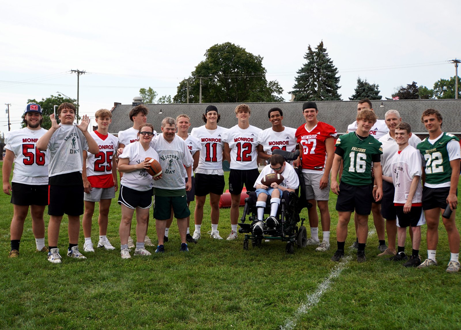 Participant Austin Price, second from the right, stands next to Victory Day founder Aaron Segedi, third from the right, and his football buddy Cole Reinhart, fourth from the right, in the green jersey.
