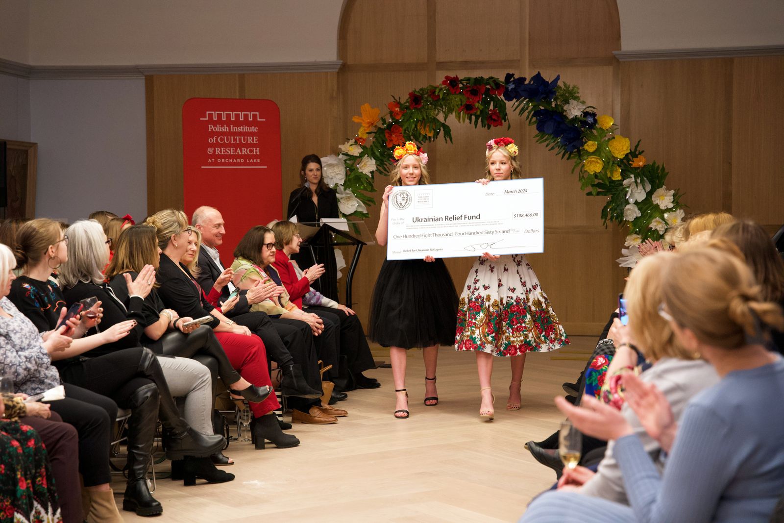 Amelia and Miriam Czarnik, juniors and twin sisters at St. Mary's Preparatory, present a ceremonial check, celebrating the total amount raised by the institute's Ukrainian Relief Fund since April 2022.
