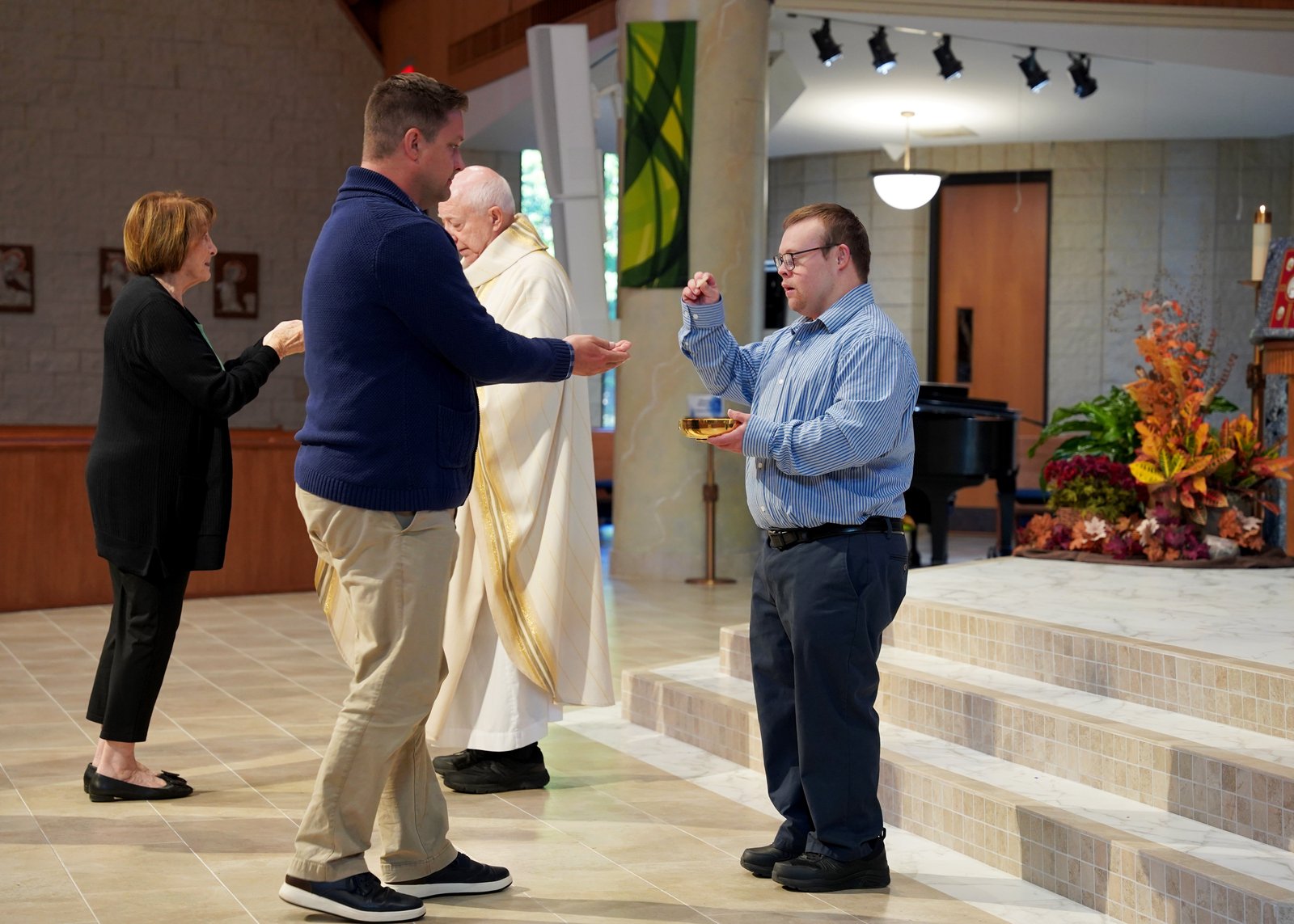 Robby Heil distributes Holy Communion during Mass on Sept. 8 at St. James.