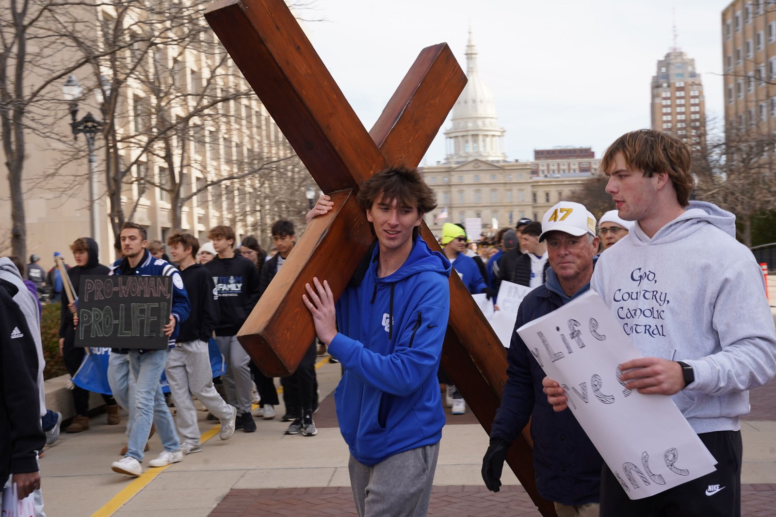 A student from Detroit Catholic Central High School in Novi carries a large wooden cross through the streets of Lansing during the Nov. 6 Michigan March for Life.