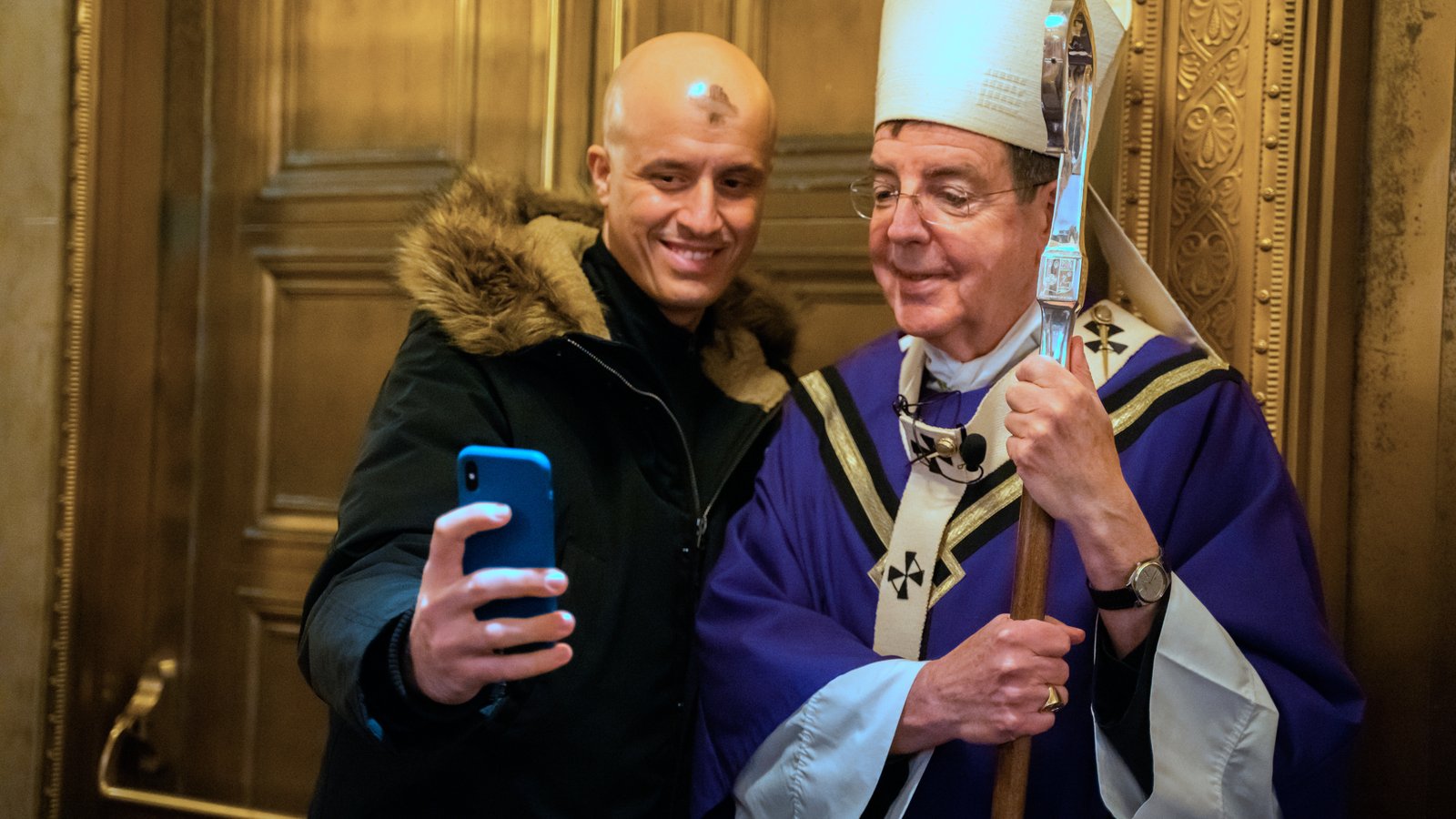 A Massgoer snaps a selfie with Archbishop Vigneron after Ash Wednesday Mass on Feb. 27, 2020, at St. Aloysius Parish in downtown Detroit. (Valaurian Waller | Detroit Catholic)