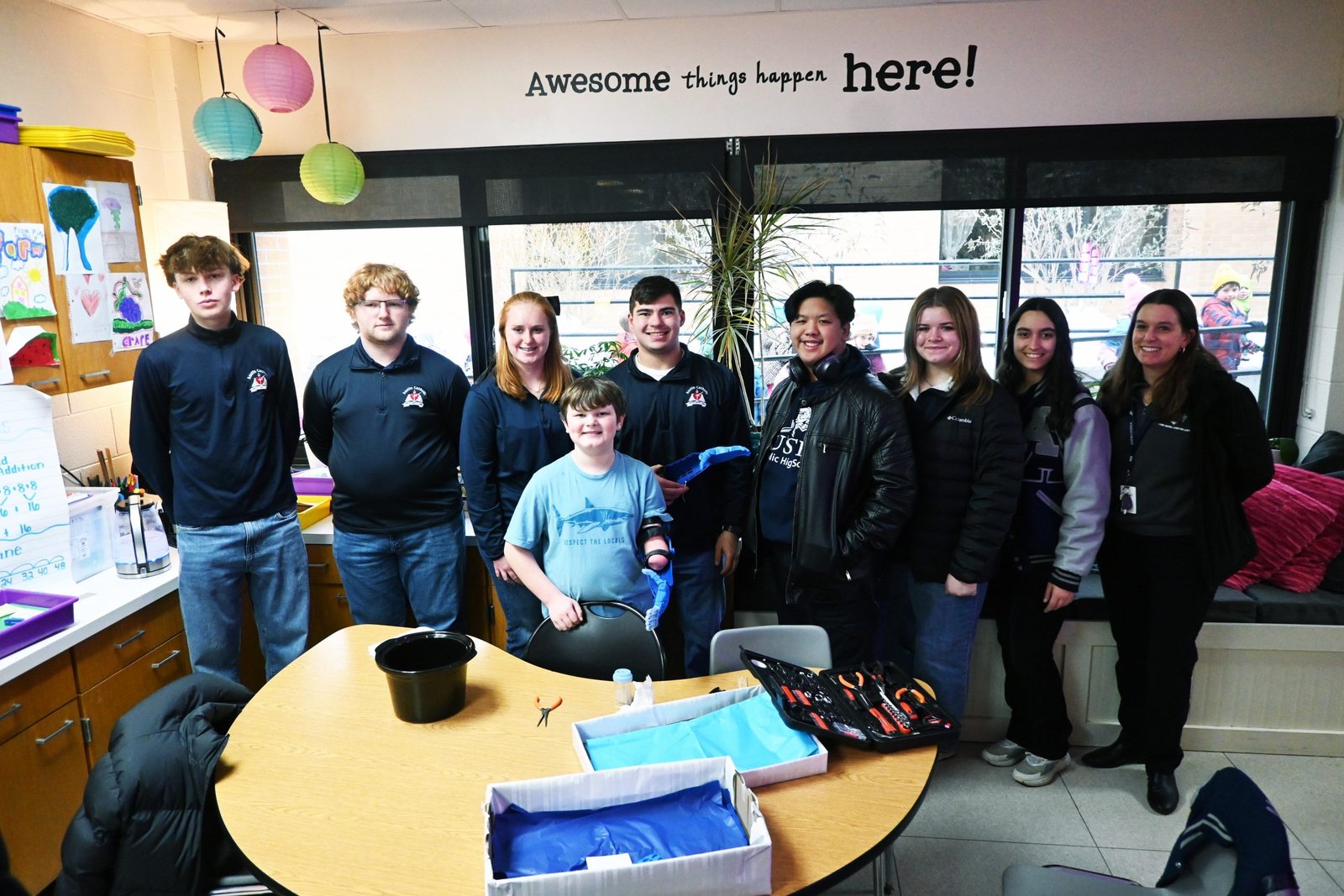 Austin Catholic High School students Matthew Hayden, Austin Ormsby, Abigail Glynn, Jacob Boutorwick, Bryce Urbano, Izabella Frederick, Elena Ferri, and teacher Laura Hayden are pictured with Kaysen Green. Three additional students worked on the prosthetic but are not pictured: Simon Osantowske, Rebecc Corbett and Joshua Dalia.