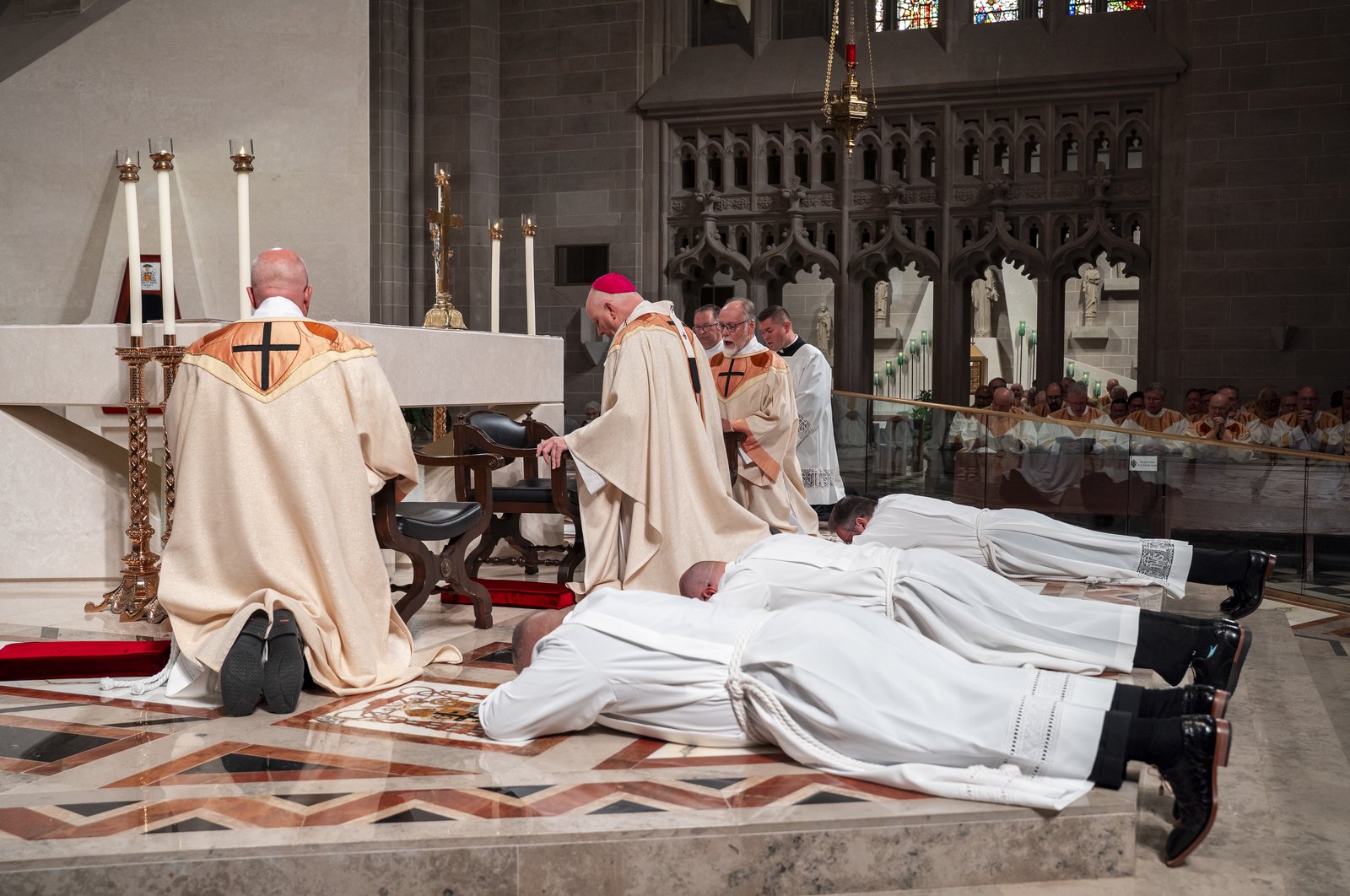The three men lay prostrate before the altar at the Cathedral of the Most Blessed Sacrament of Detroit, waiting to be ordained permanent deacons by Detroit Archbishop Edward J. Weisenburger.