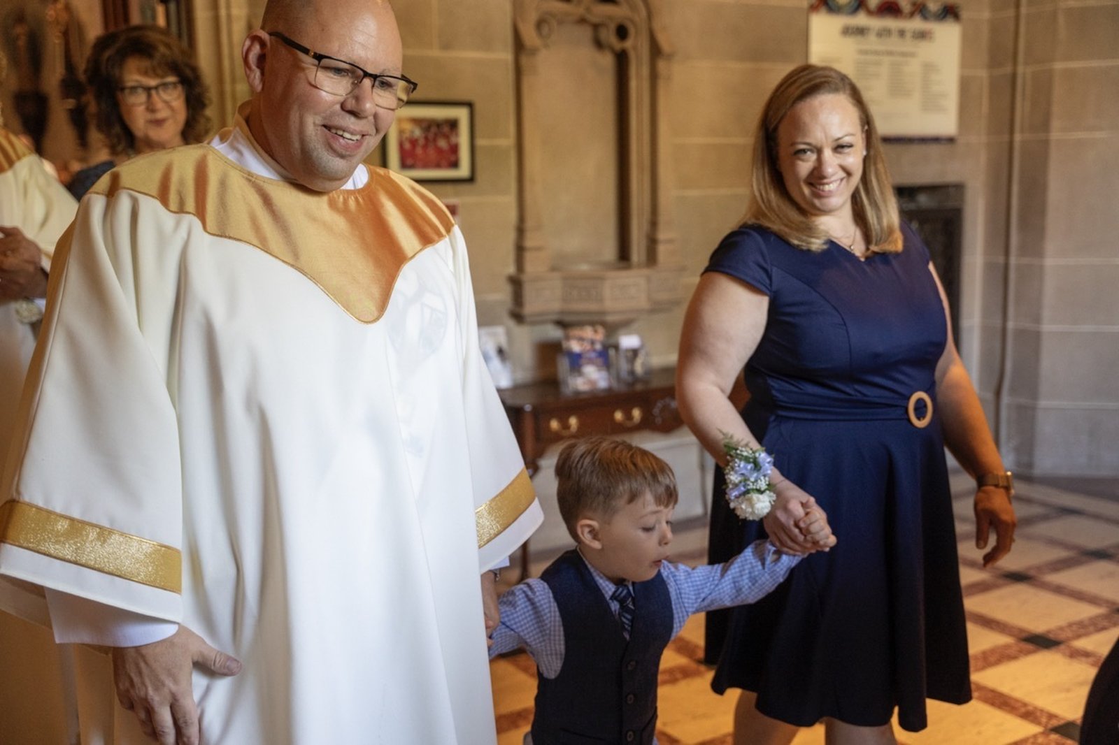 Deacon John Kovacik and his wife, Bernadette, each hold a hand of their 3-year-old son, Noah.