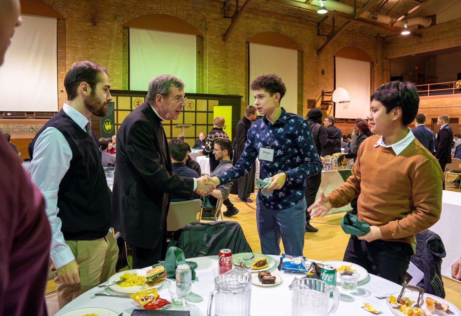Archbishop Allen H. Vigneron greets young men in the Sacred Heart Major Seminary gymnasium Feb. 18, 2025, during an annual evening of prayer and dinner hosted by the Office for Priestly Vocations. (Valaurian Waller | Detroit Catholic)