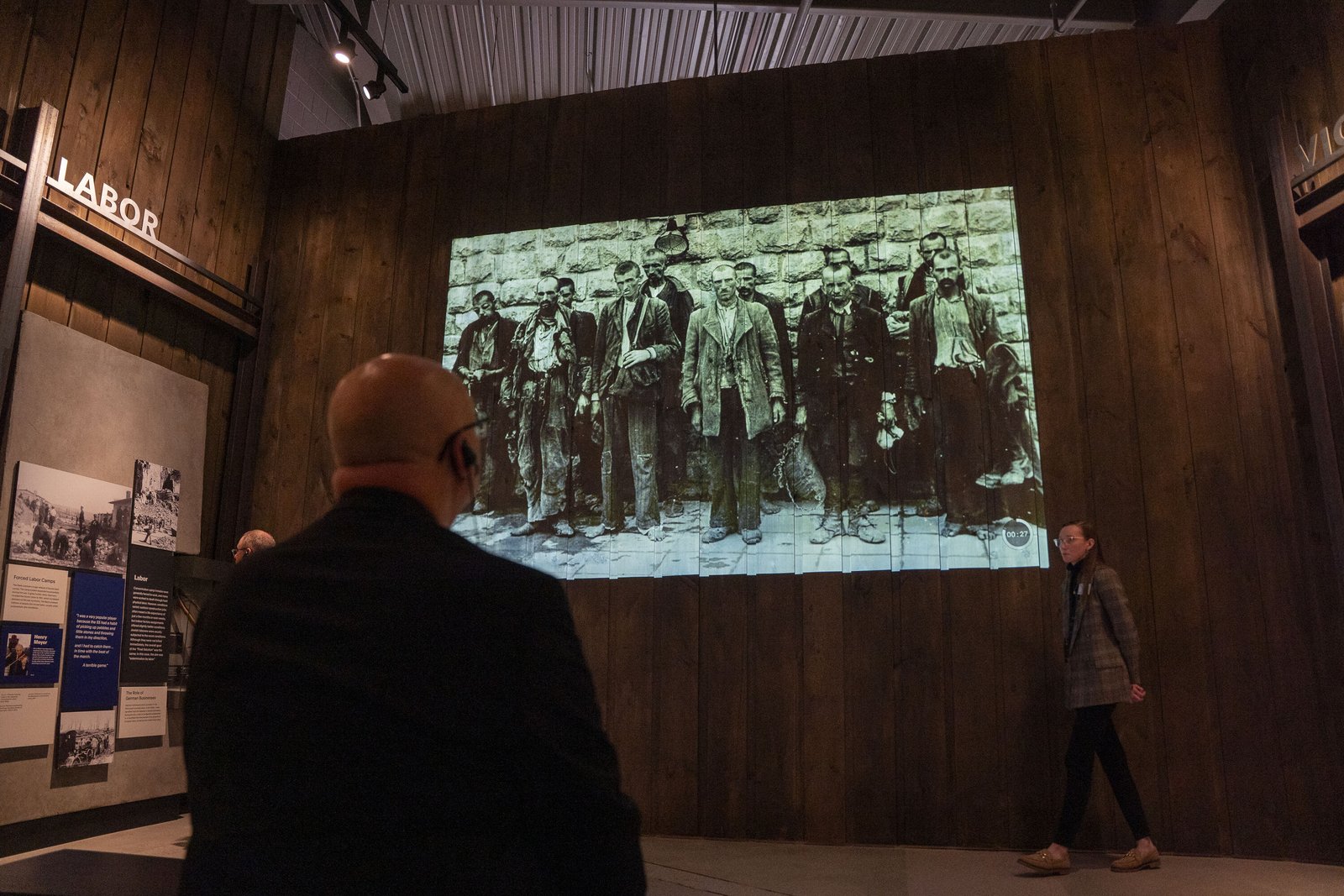 Jamie Miskowski, right, education manager at The Zekelman Holocaust Center, speaks about the Nazi labor camps as Archbishop Weisenburger, left, listens.