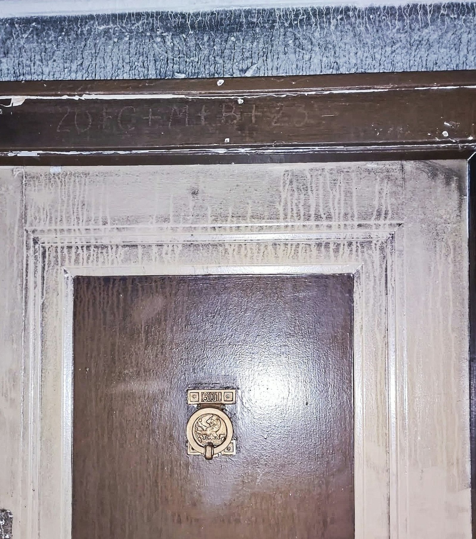 Las marcas escritas en tiza "20+C+M+B+23" todavía podían verse sobre la puerta de Alexander después de que un incendio en su edificio causara muchos daños por el humo. Un hombre que vio las marcas de Epifanía le dijo a Alexander que, de todas las viviendas, la suya era una de las menos dañadas. (Foto cortesía de Jeremy Alexander)