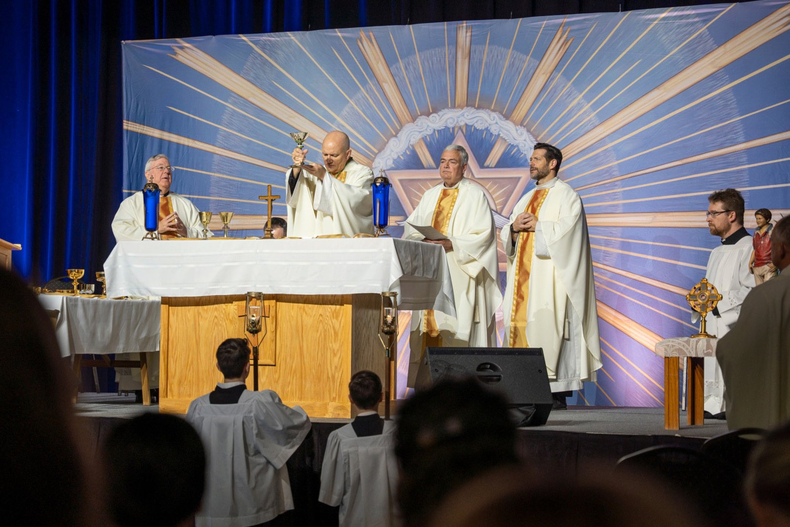 Archbishop Weisenburger elevates the Eucharist during Mass at the Suburban Collection Showplace in Novi during the first-ever F.I.R.E. conference on April 4.