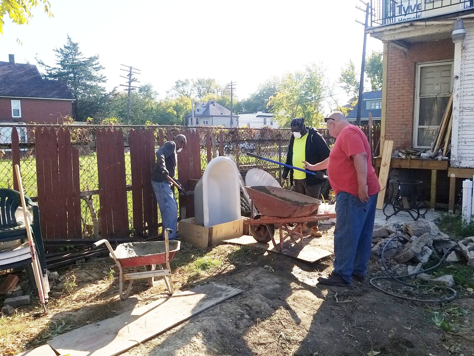 Volunteers and workers build a niche for a Marian grotto.