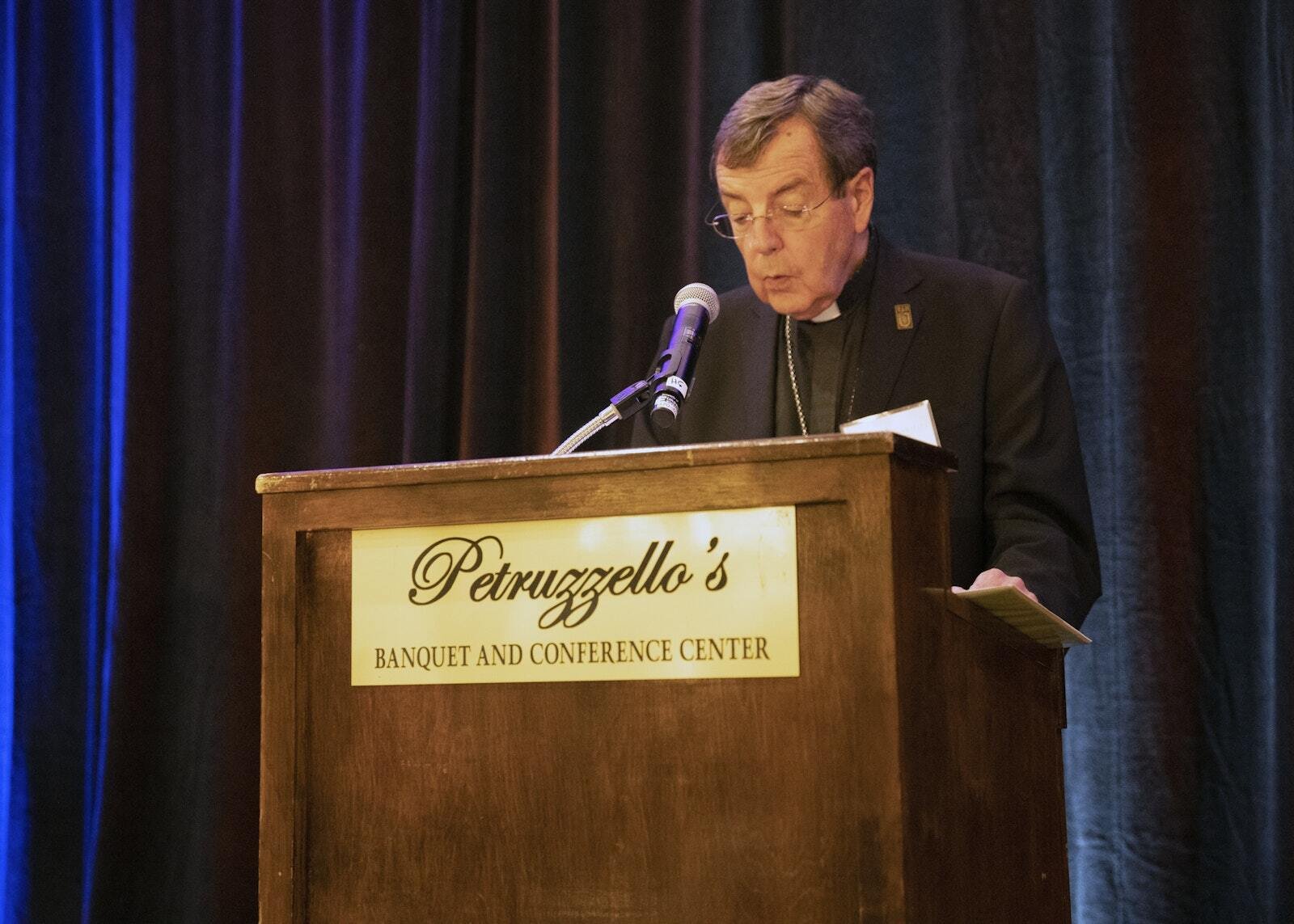 El Arzobispo Allen H. Vigneron bendice los alimentos antes de cenar. El arzobispo agradeció a los que apoyan a Catholic Charities of Southeast Michigan, la agencia principal para las obras de misericordia de la Arquidiócesis de Detroit.