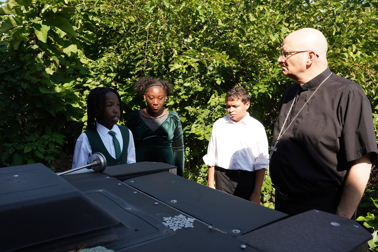 Gesu students show Archbishop Weisenburger the composter where leftover meat from the lunch periods is composted. Gesu school officials estimate they save $1,200 in trash pickup because of their sustainability efforts.