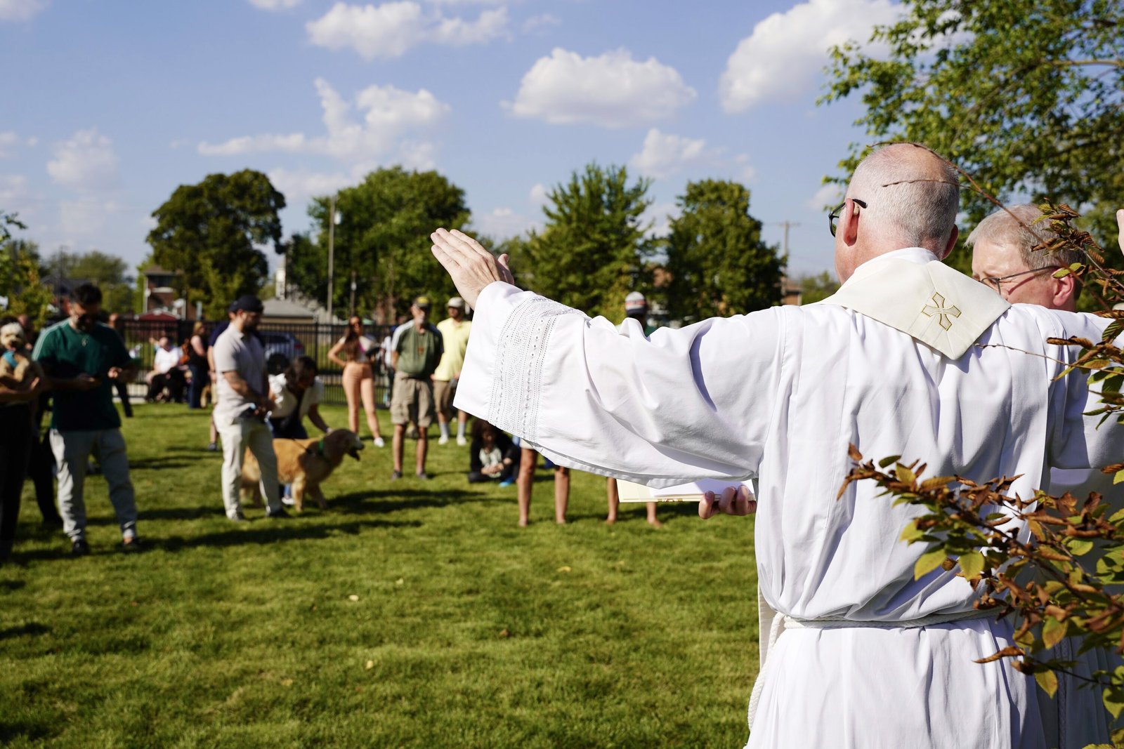 Fr. Mech extends his hands in blessing over the new park, which will continue to draw neighbors together in friendship, community and faith.