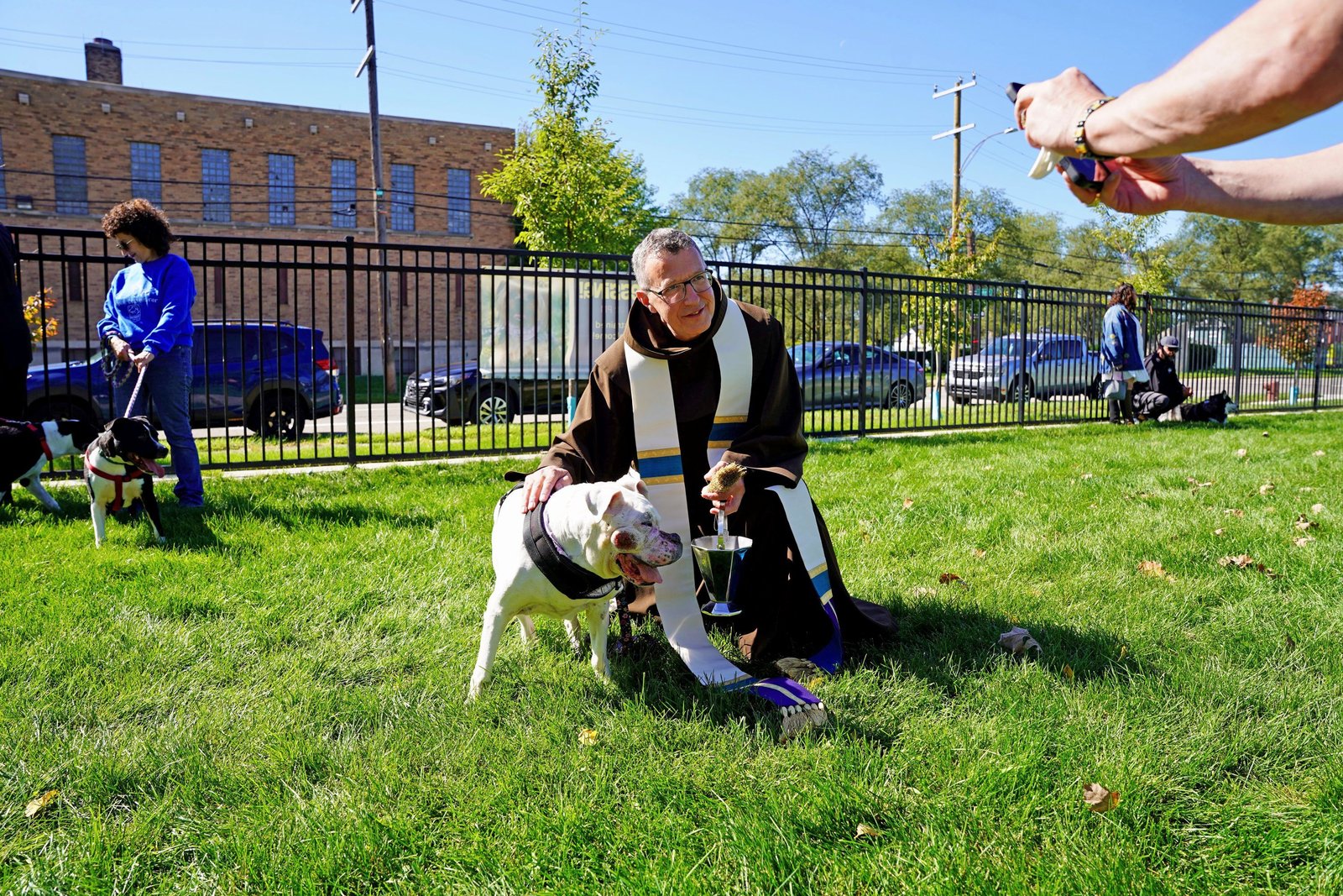 Fr. Mark Soehner, OFM, poses for a photo with one of the canine companions brought to the dog park for a blessing. Fr. Soehner reflected upon the relationship of God's creation to the life of faith on the 800th anniversary of the death of St. Francis of Assisi.