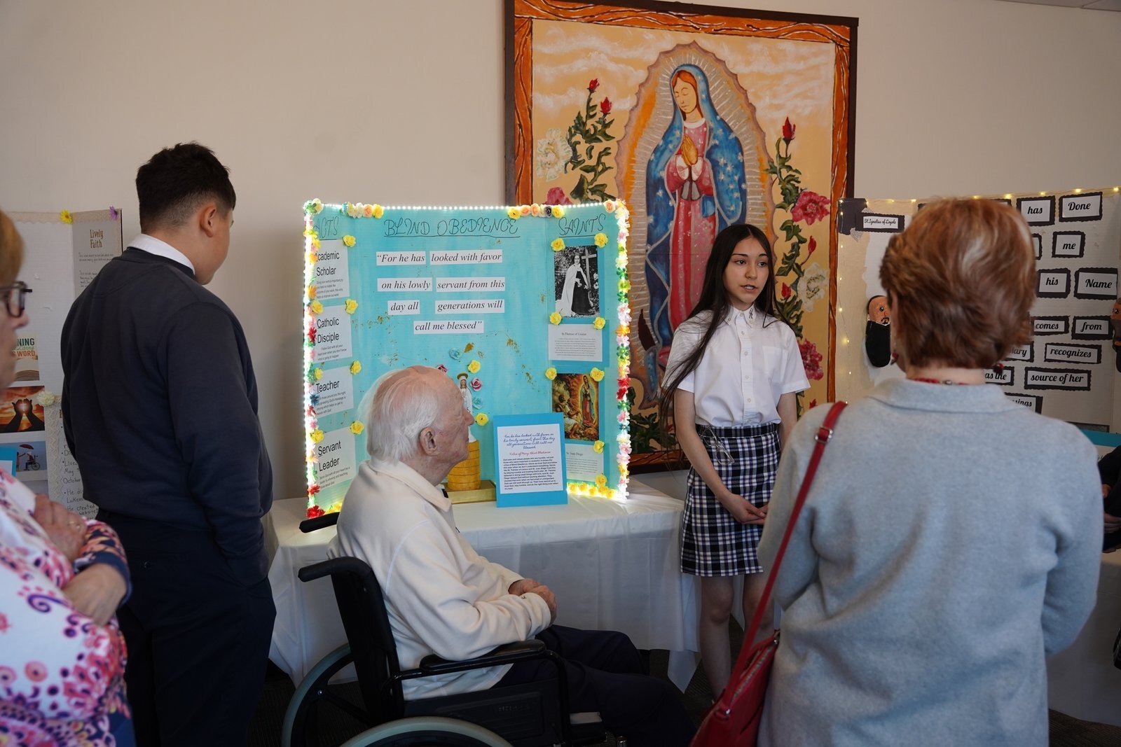 Un estudiante de octavo grado de Holy Redeemer explica a exalumnos y donantes de la escuela los distintos aspectos del Magníficat.