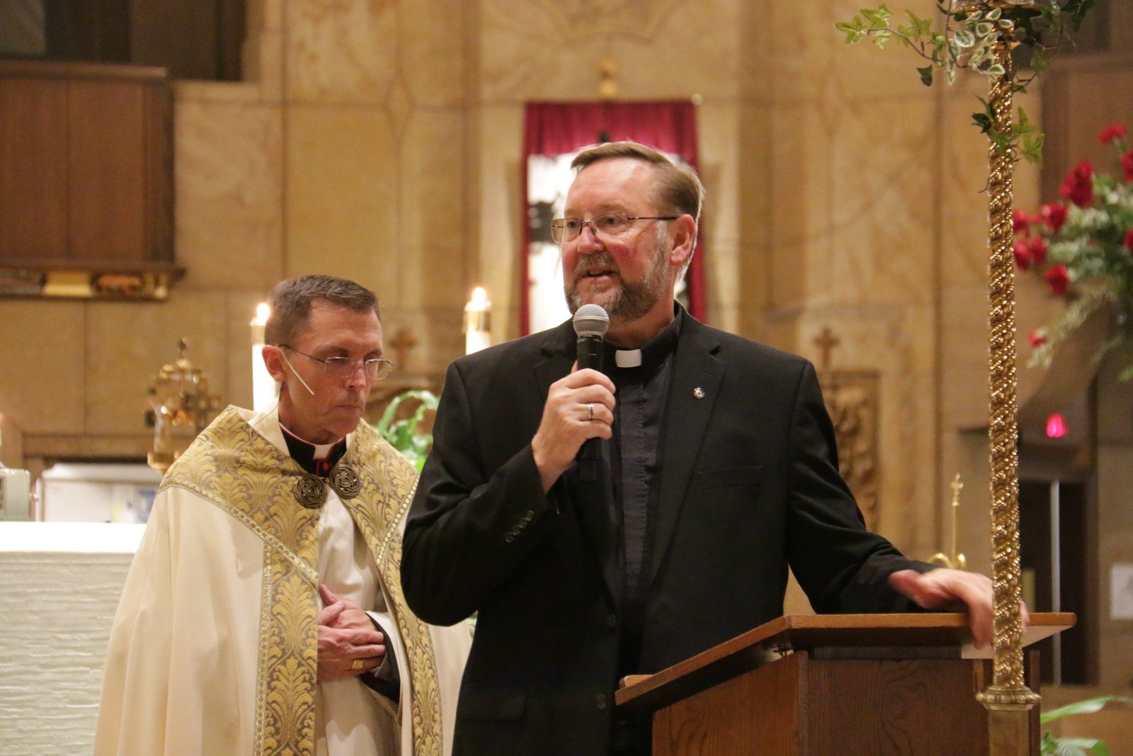 El padre Joe Horn, rector y párroco del Santuario Nacional de la Basílica de la Pequeña Flor en Royal Oak, presenta al Obispo auxiliar de Boston, Robert Reed, durante el primer evento de la serie de oradores "Live at the Basilica" de la basílica el 27 de octubre.