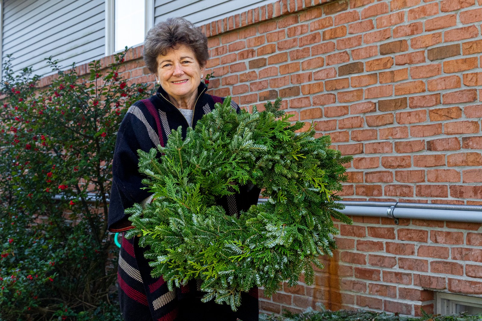 Catherine Genovese holds a wreath made for sale at Candy Cane Christmas Tree Farm. The farm opens for the season the weekend before Thanksgiving each year.