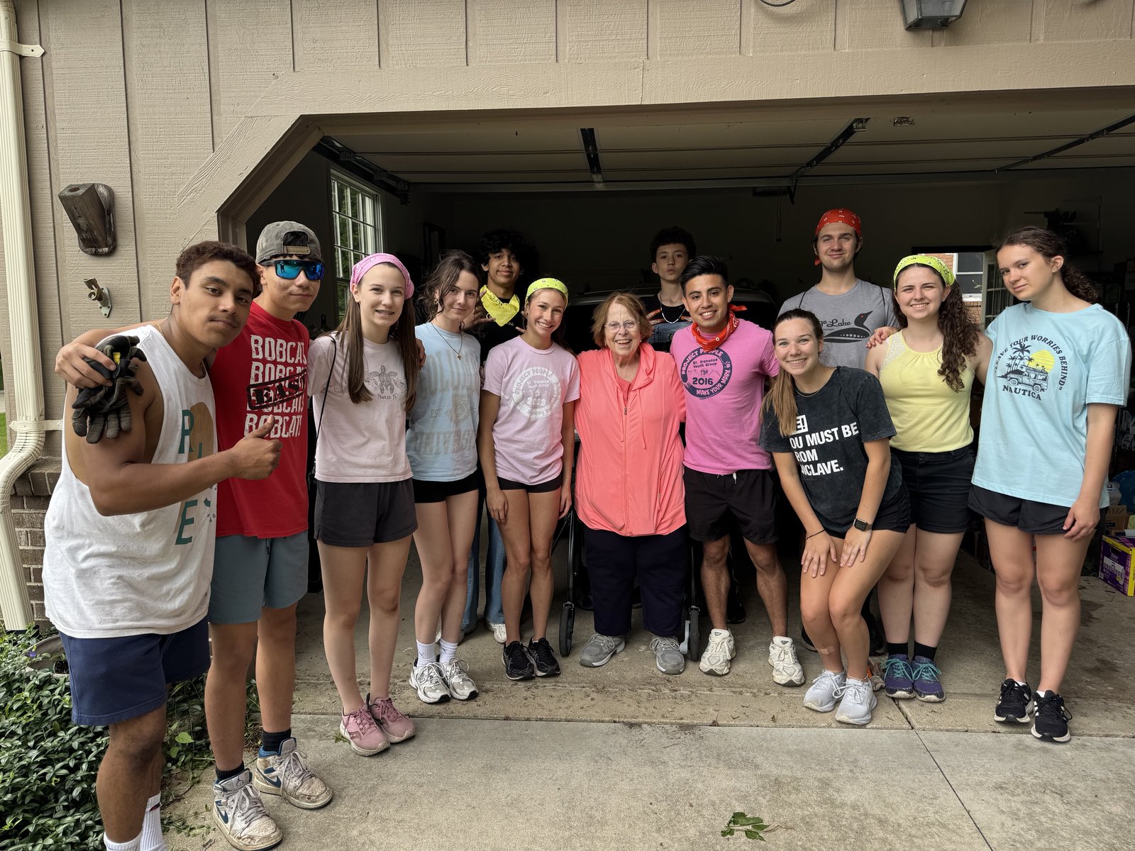 St. Irenaeus teenagers pose for a photo with a homeowner after completing yardwork during Project People, an annual summer service project. (Courtesy of St. Irenaeus Parish)
 