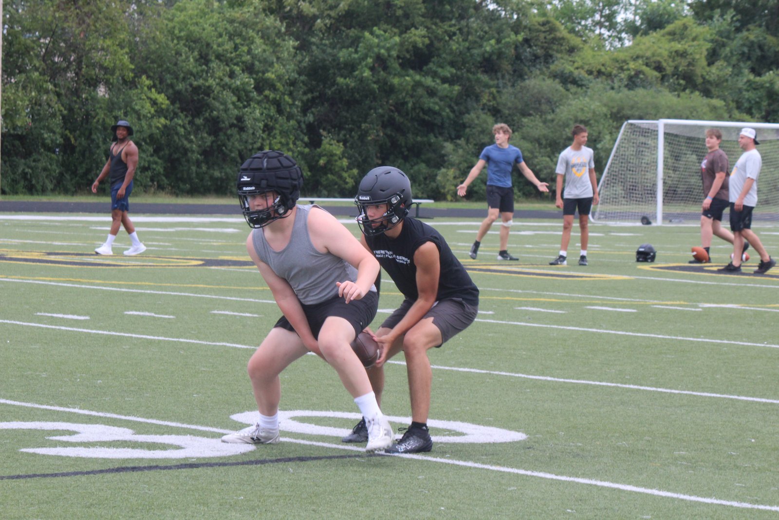 Fall sport practices are now under way, as Bishop Foley quarterback Jacob Thompson takes a snap from his center, Dash Sweeney. The Ventures are now under the guidance of new head coach John Maltese. (Photo by Wright Wilson | Special to Detroit Catholic)