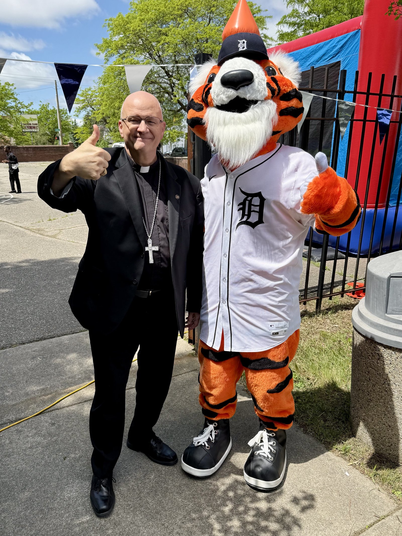 Archbishop Weisenburger gives a big thumbs up alongside "Paws," the mascot of the Detroit Tigers, who was in attendance for a reception after Mass at St. Moses the Black Parish in Detroit on May 18.