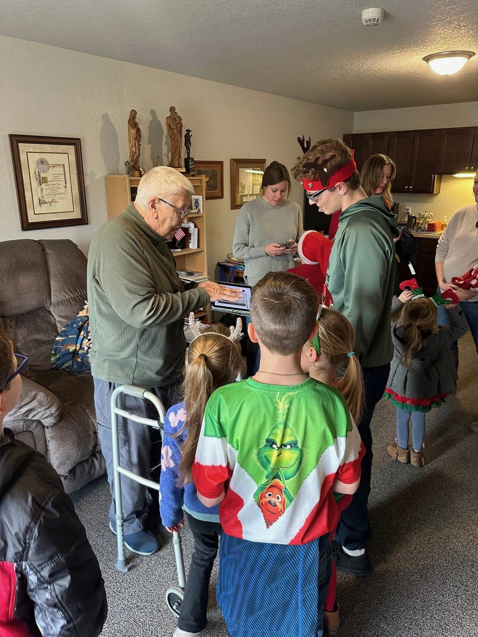 In December, members of the youth group, moms group, and faith formation classes surprised Fr. Treml, singing carols for the residents and catching up with their former pastor. (Courtesy of Kathleen Reed)