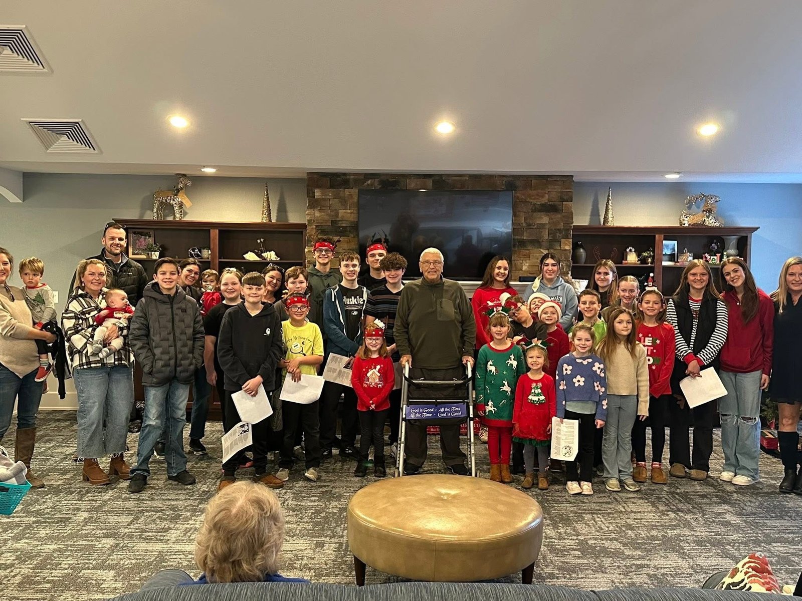 Members of the youth group, moms group, and faith formation classes take a group photo with Fr. Treml during a visit with their former pastor in December. (Courtesy of Kathleen Reed)