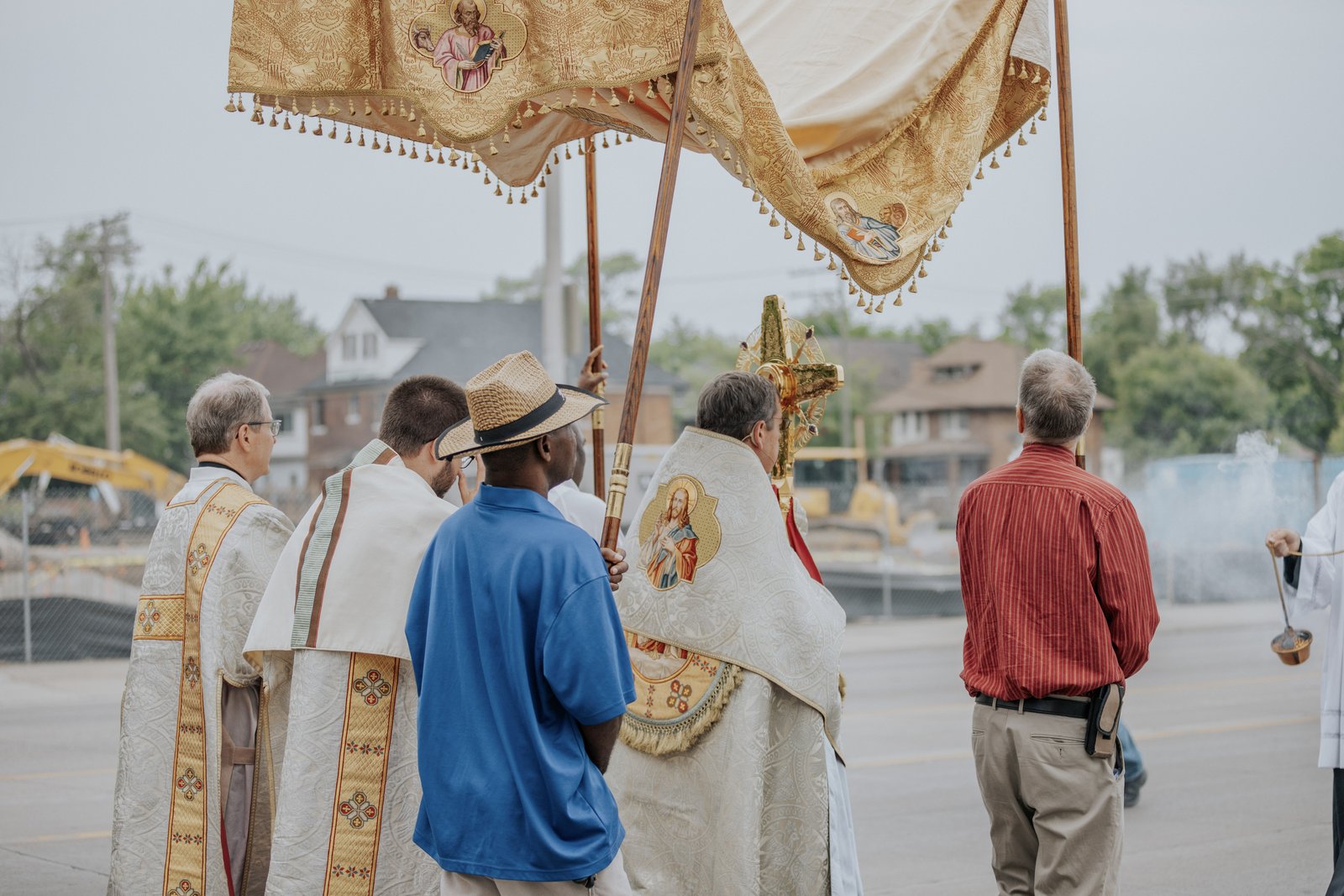 Archbishop Vigneron holds the monstrance containing the Eucharistic Jesus as the procession passes by the construction site of the Cathedral Arts Apartments, a new venture that will build 53 affordable housing units for Detroit's low-income residents across the street from the Cathedral of the Most Blessed Sacrament. (Alissa Tuttle | Special to Detroit Catholic)