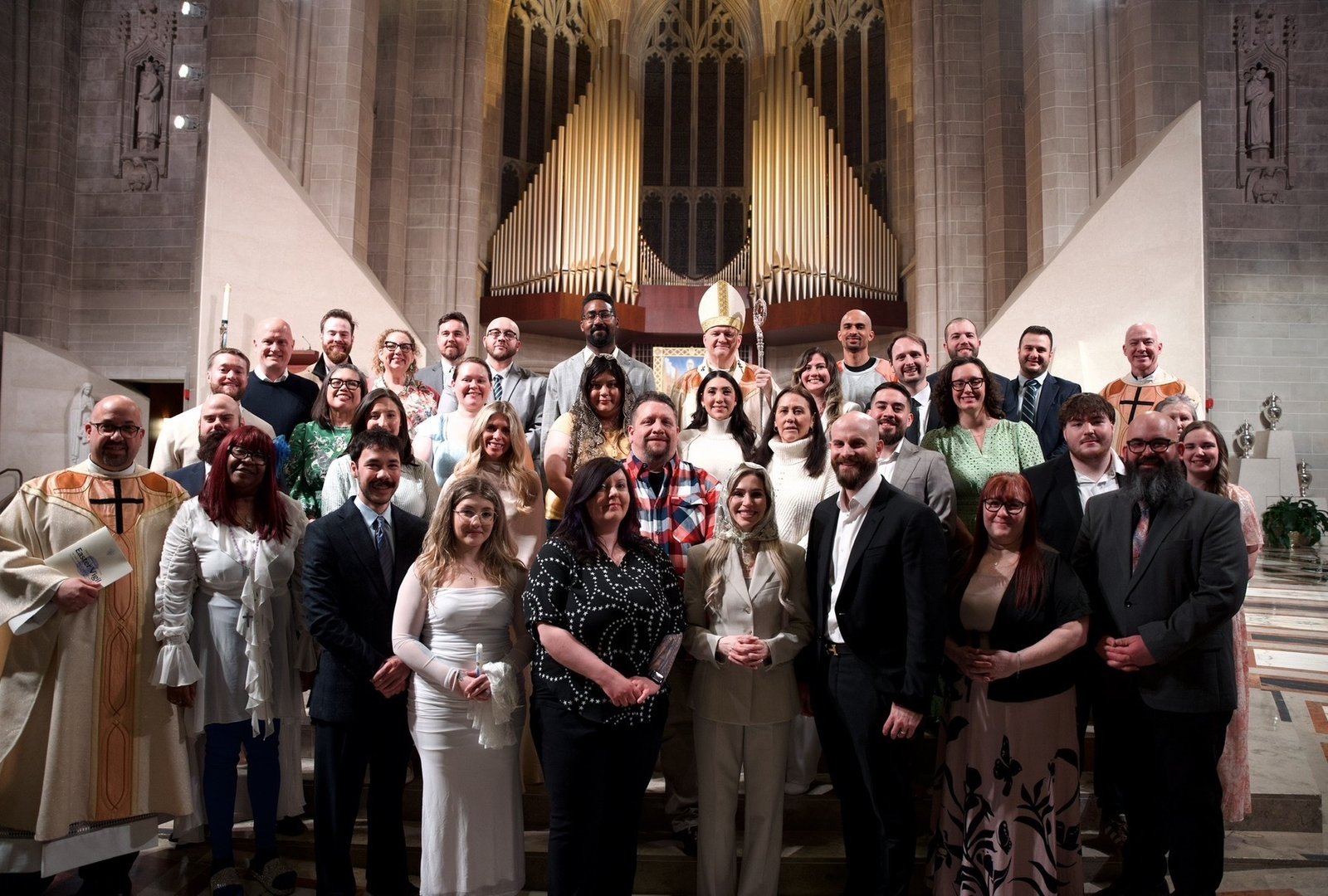 Archbishop Weisenburger poses for a photo with the candidates and catechumens who became fully welcomed into the Catholic faith at the Cathedral of the Most Blessed Sacrament during this year's Easter Vigil.