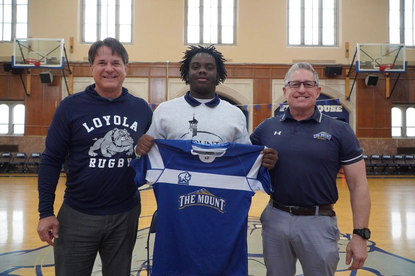 Detroit Loyola rugby coach Ron Cornell and Mount St. Mary’s University coach Jay Myles flank Loyola senior Raylon Murry after he signs his national letter of intent to compete at the collegiate level. (Photo courtesy of Loyola Athletic Department)