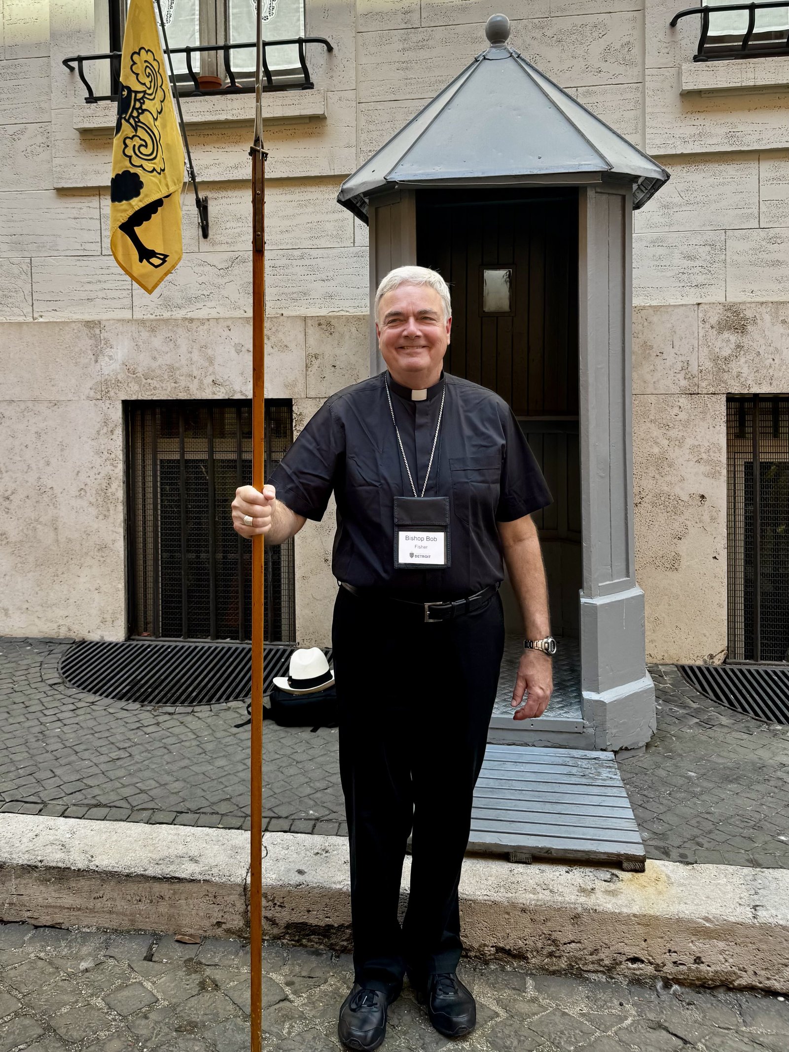Auxiliary Bishop Robert J. Fisher holds a halberd during a visit to the Swiss Guard.