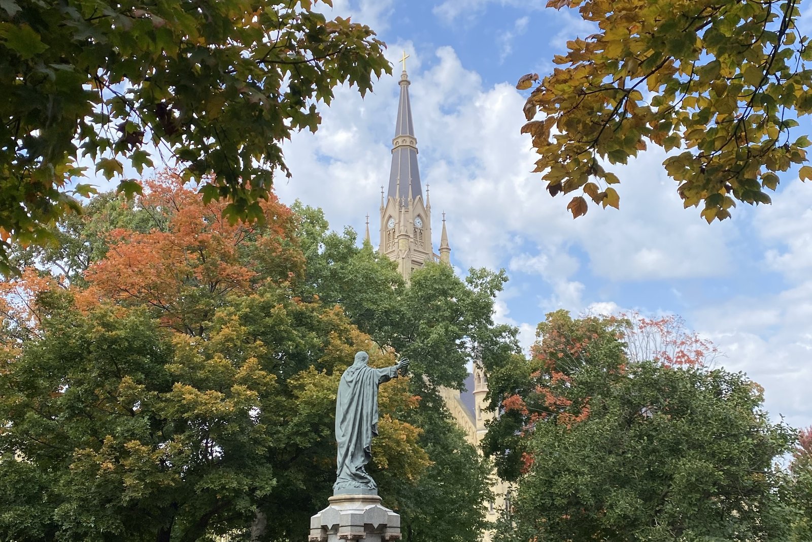 A statue of the Sacred Heart of Jesus is pictured from behind with the Basilica of the Sacred Heart in the background on the campus of the University of Notre Dame in South Bend, Ind. (Karla Dorweiler | Special to Detroit Catholic)