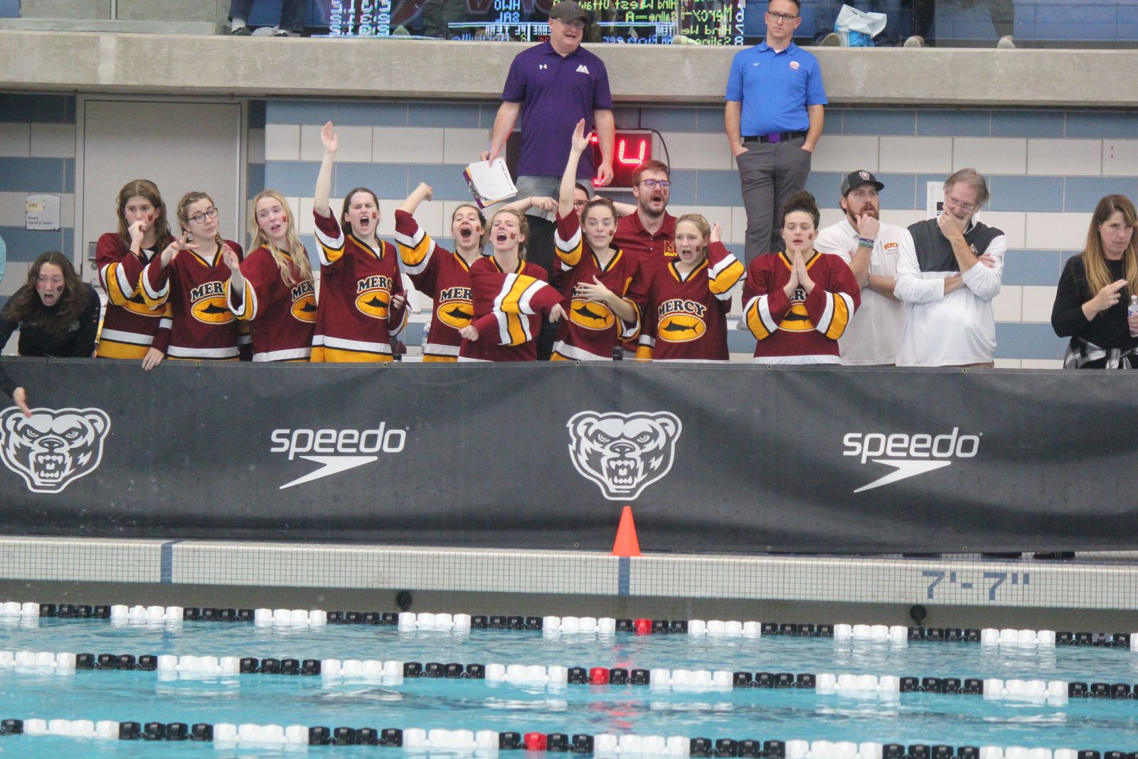 The Farmington Hills Mercy state qualifiers cheer on their teammates during the 400-yard freestyle relay at the Division 1 championship meet. (Wright Wilson | Special to Detroit Catholic)