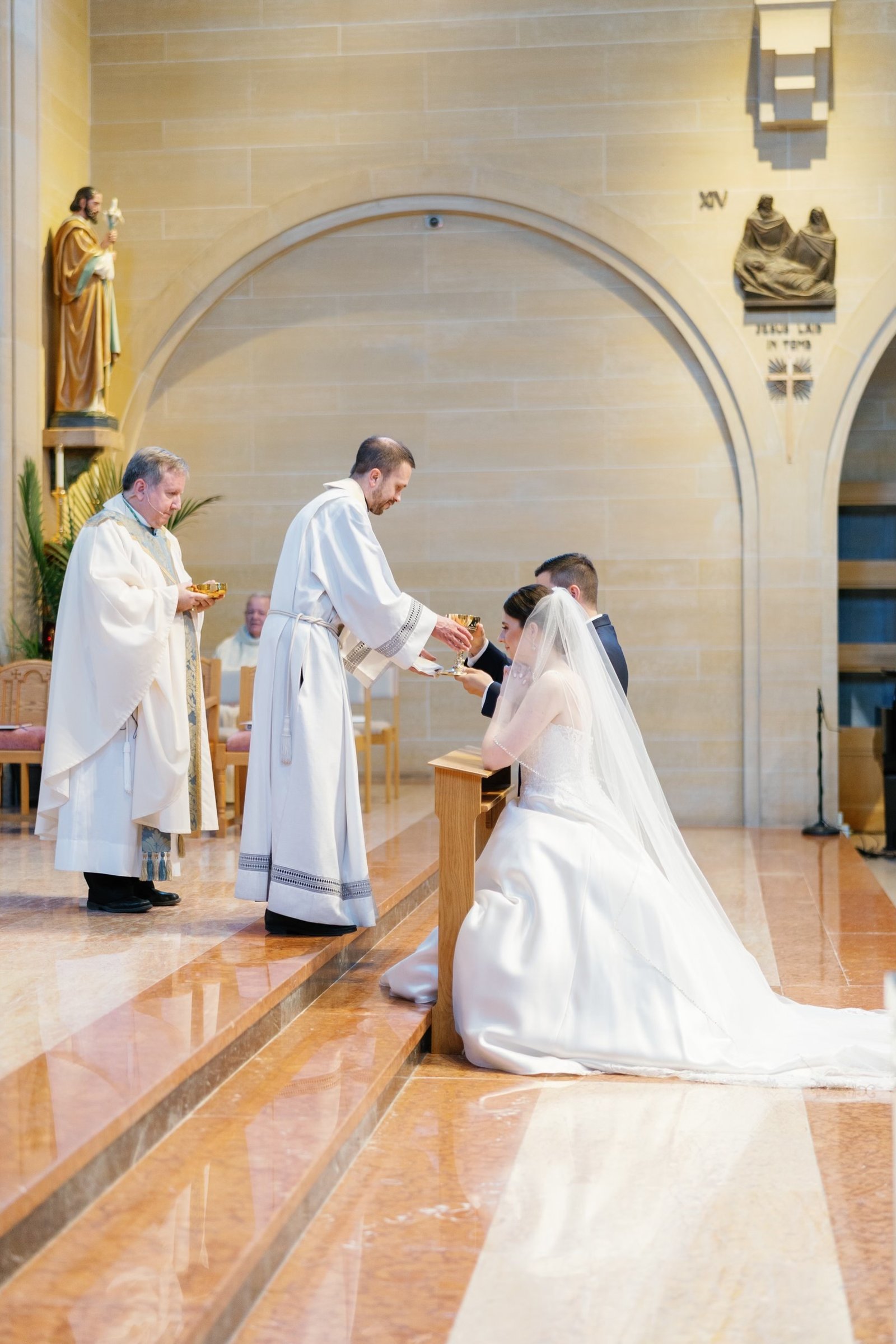 Fr. Paul Snyder offers Communion to Margaret and Ben Diaz during their wedding on May 13, 2023, at St. Mary Parish in Royal Oak, as Bishop Robert J. McClory, left, Margaret's uncle, looks on. (Photos by Shannell Photography | Special to Detroit Catholic)