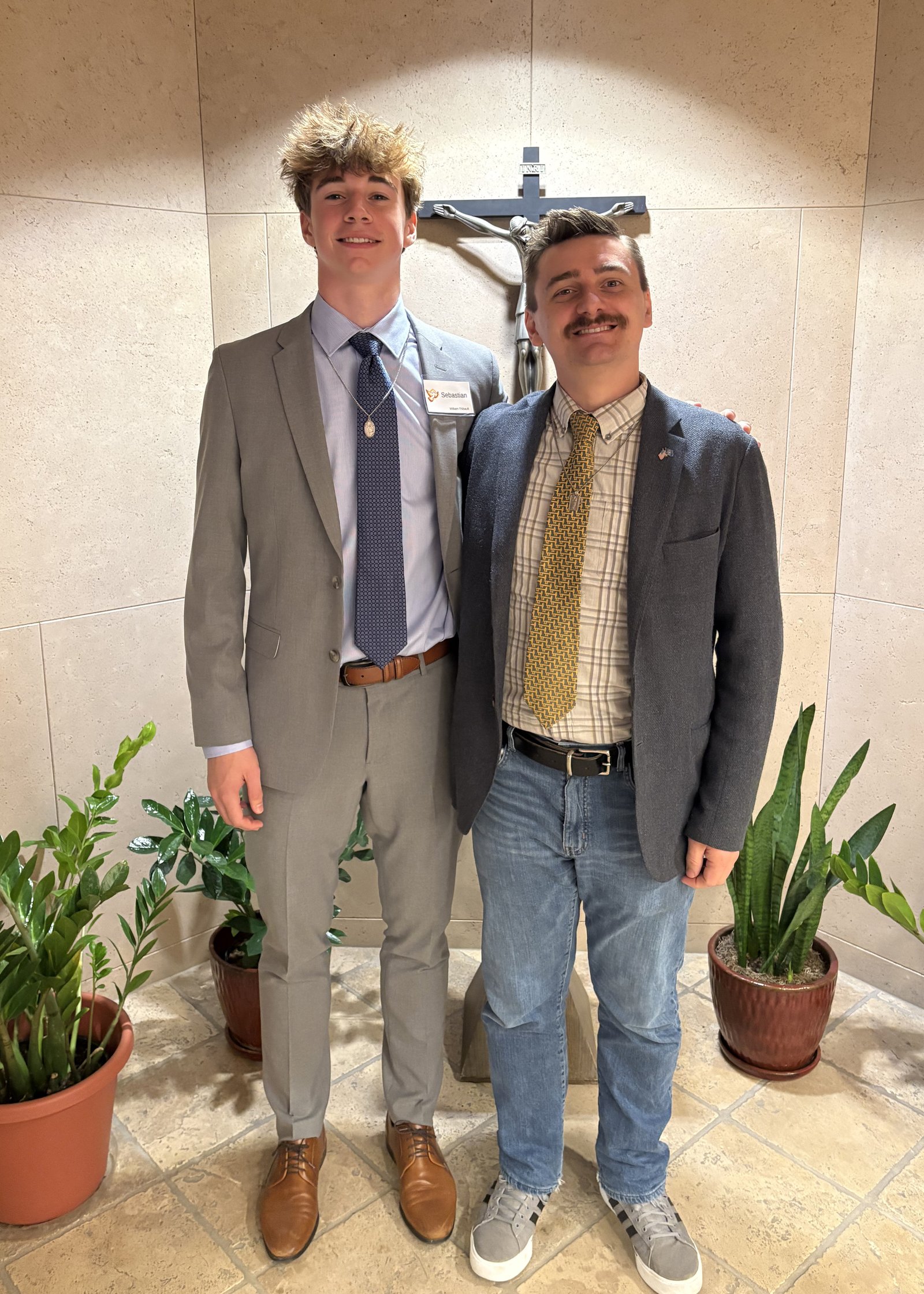 Brian Folmar, Shrine Catholic High School theology teacher, takes a photo with William Thibault, a Shrine graduate who came into the Church in April.