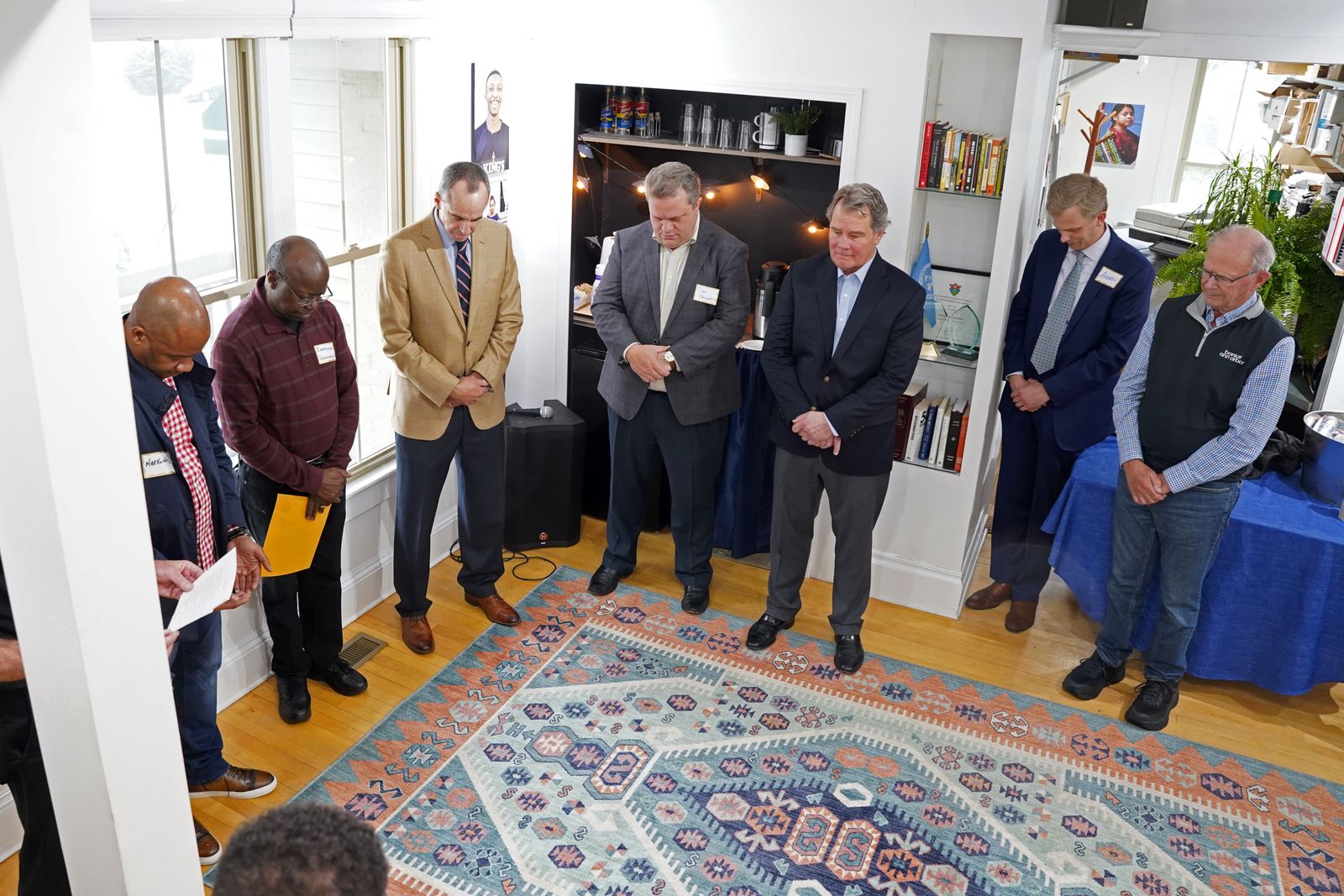 International Samaritan board members and supporters pray during a flag-raising ceremony April 28 outside the nonprofit's Ann Arbor headquarters to mark its expansion in east Africa.