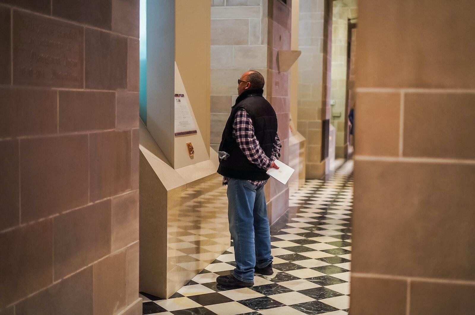 Un hombre se detiene para contemplar y leer acerca de uno de los santos que se encuentran en la pared norte de la catedral. Debajo de cada estatua, hay una descripción de cada apóstol y su reliquia de primer grado, que los peregrinos pueden venerar y utilizar para orar.