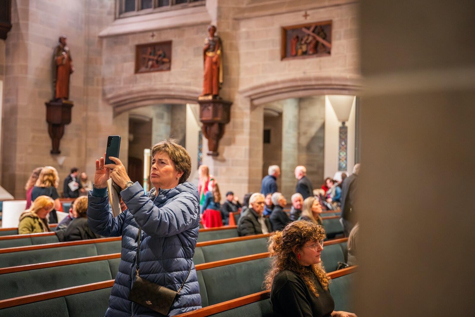 Una mujer toma una foto de una de las estatuas y reliquias recién instaladas. La peregrinación ‘Journey with the Saints’ estará permanentemente disponible para los visitantes de la catedral, y se invita a aquellos que experimenten milagros como resultado de sus oraciones a que regresen y contribuyan a la creación de un nuevo mosaico.