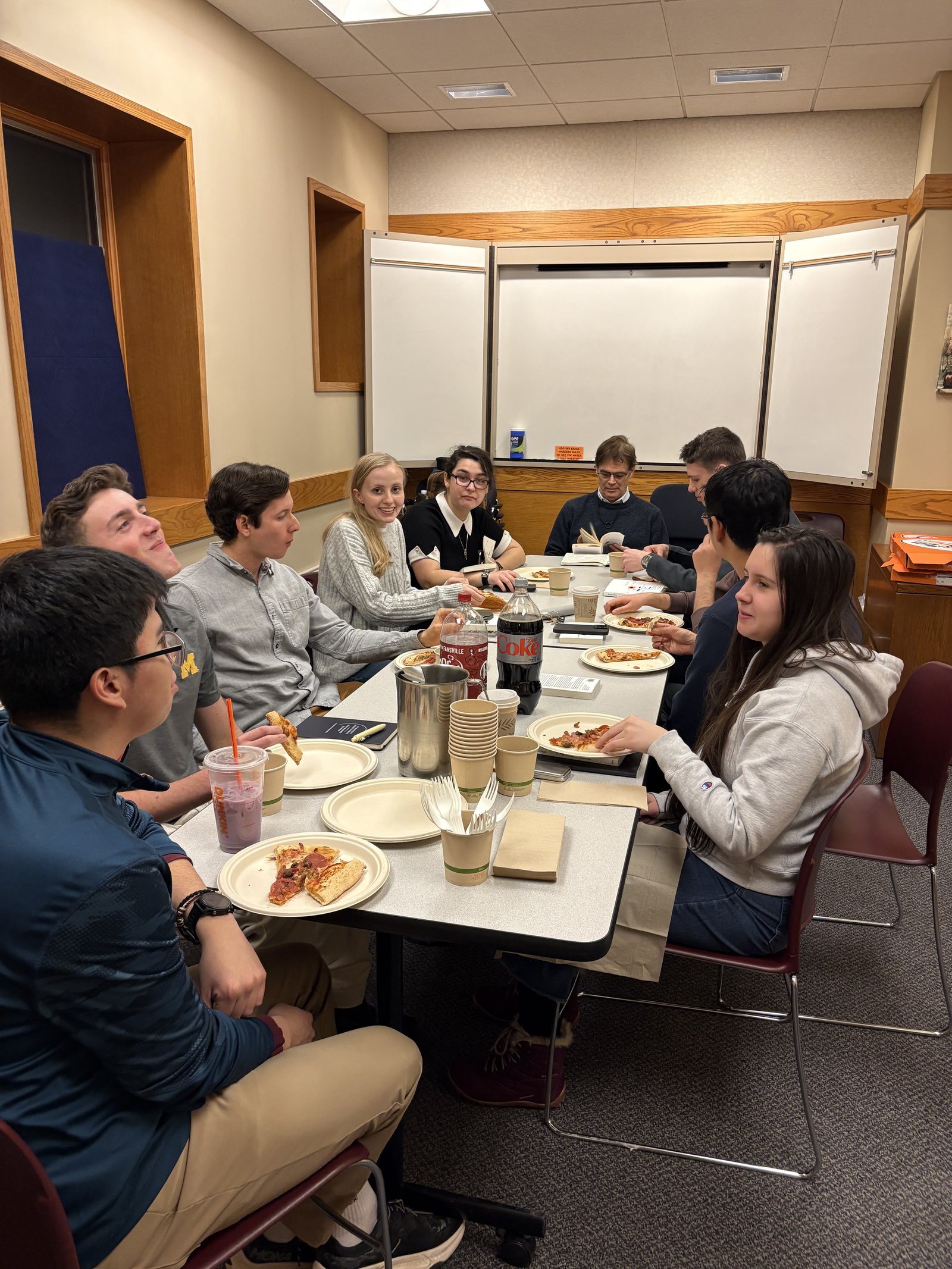 Undergraduates at the University of Michigan share in a pizza party following a film screening at a Kateri Institute "Cinema Sanctus" event.