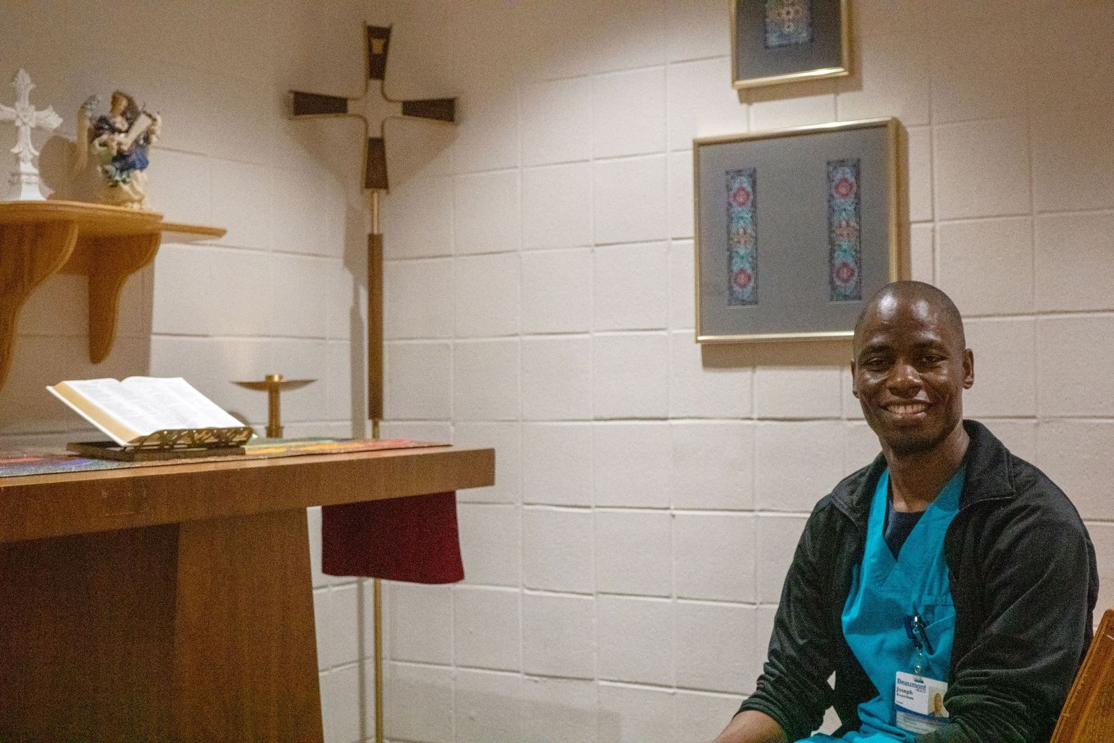Joseph Kirembwe, 36, stops in the chapel to pray before his shift. Kirembwe says his Catholic faith helps him to be a better caregiver, and he loves sharing his faith with others. (Matthew Rich | Special to Detroit Catholic)