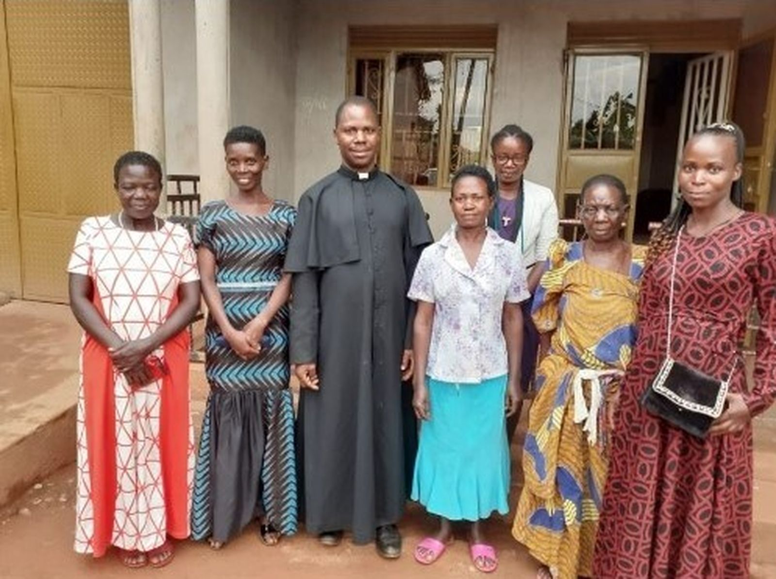 Joseph's brother, Fr. Denis Ssebuggwawo of Holy Family Catholic Parish in Kampala, Uganda, visits with his mother, Cotilda Nakamatte, sisters and cousins at the family home. (Courtesy of Joseph Kirembwe)