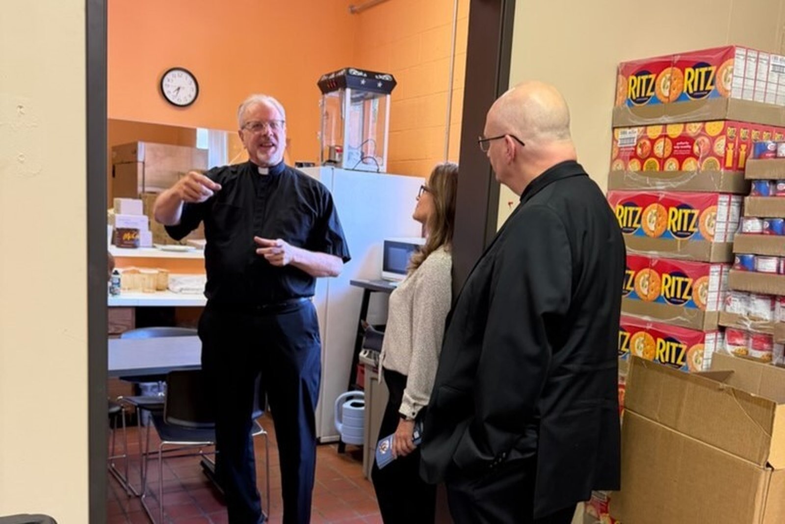 Fr. David Buersmeyer, ombudsman for the Archdiocese of Detroit and chaplain to Strangers No Longer, speaks with Archbishop Weisenburger and Luz Acosta about La Casa Amiga's food bank, which operates fives days a week, serving up to 70 families a week.